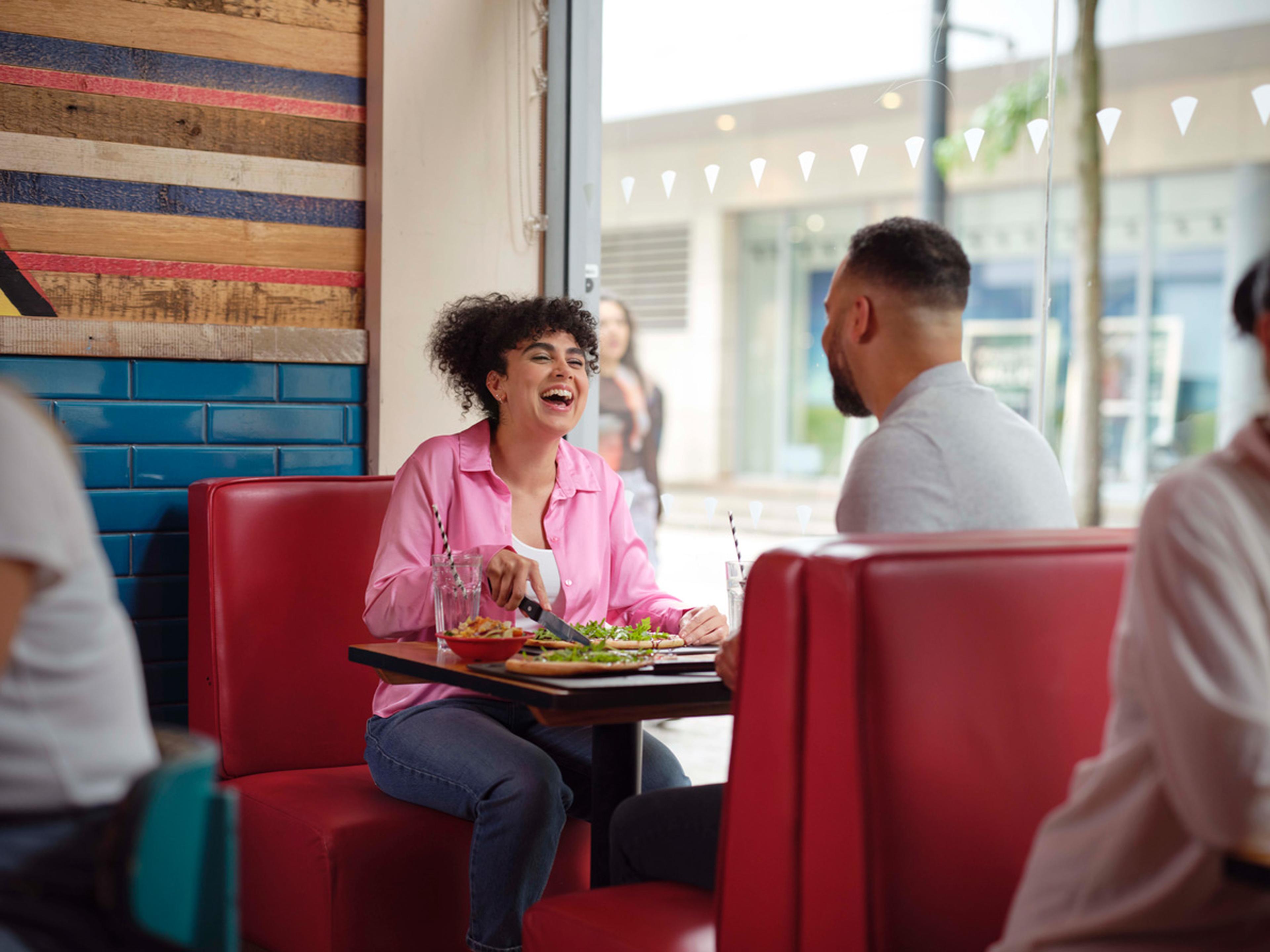 Couple enjoying pizza at a local restaurant.