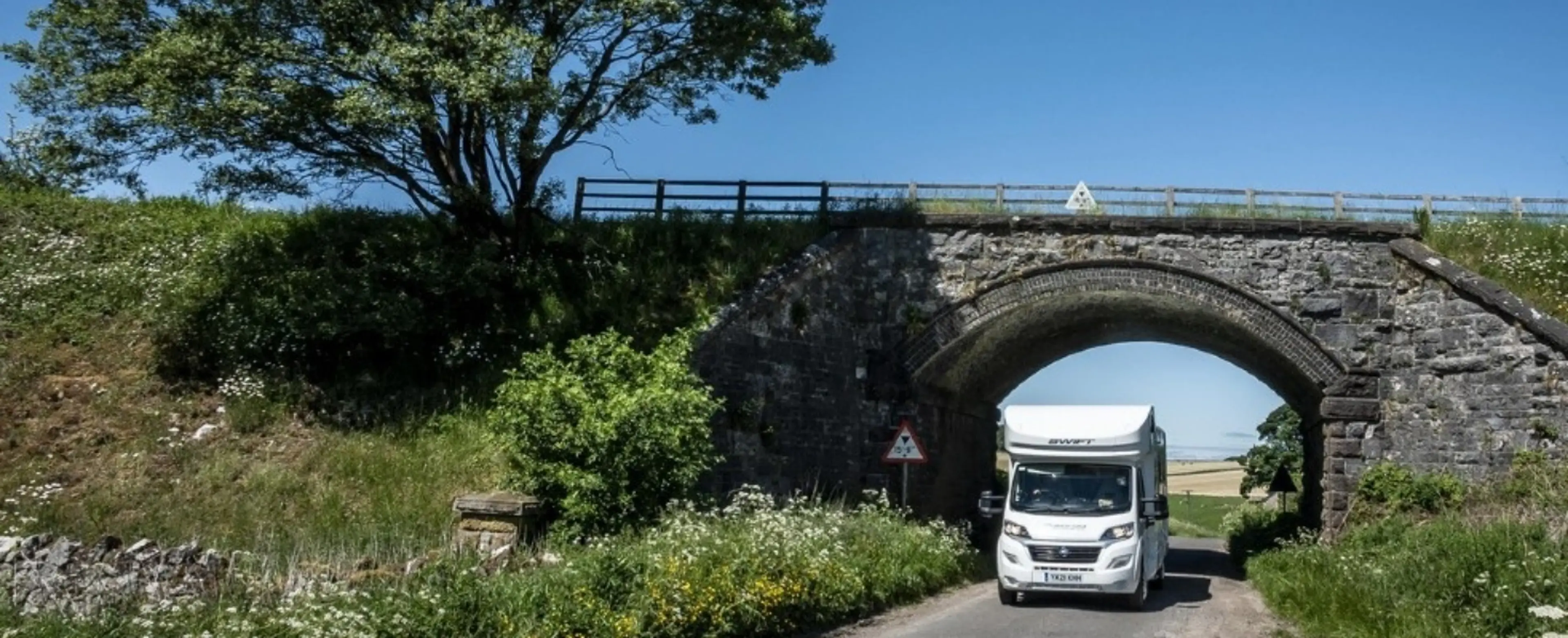Motorhome driving underneath a railway bridge