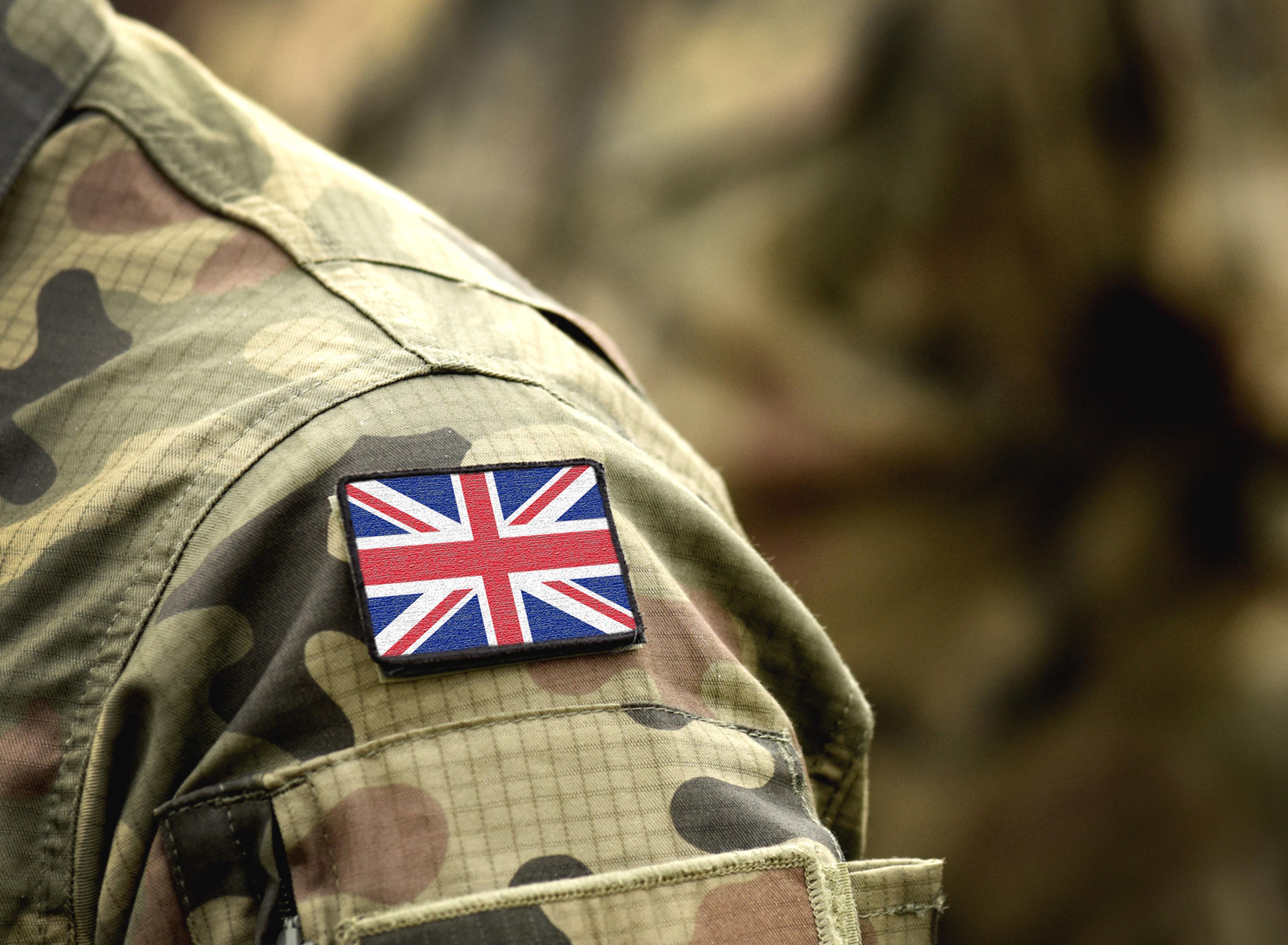 Camouflage uniform with a British flag patch on the shoulder, highlighting military affiliation.