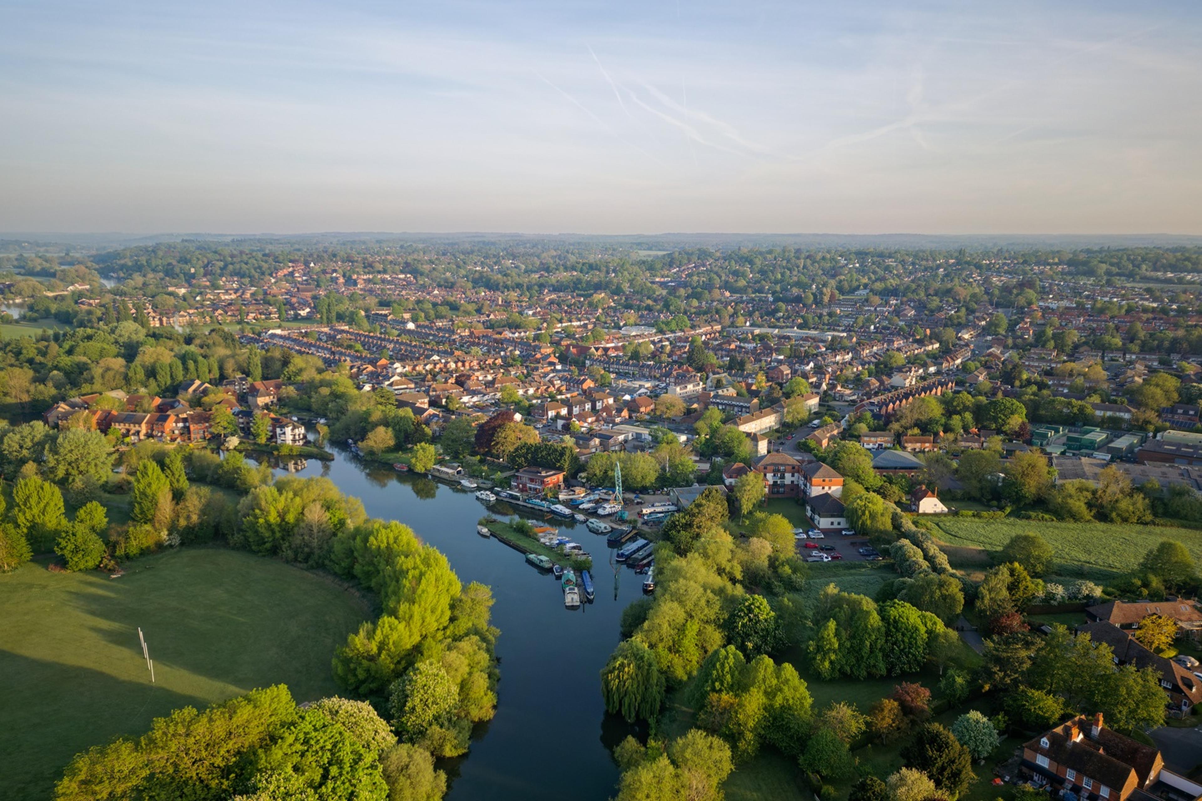 Aerial view of a picturesque town with a river, surrounded by lush greenery
