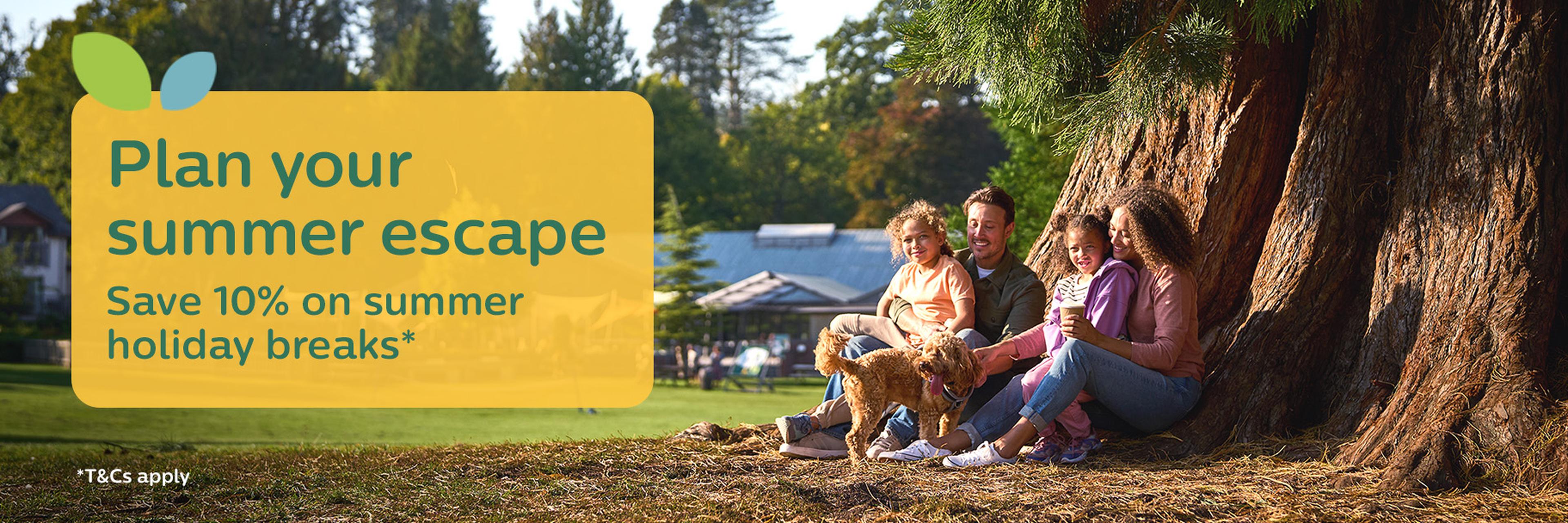 Family relaxing by a tree, enjoying nature with their dog. Text overlay: "Plan your summer escape. Save 10% on summer holiday breaks."