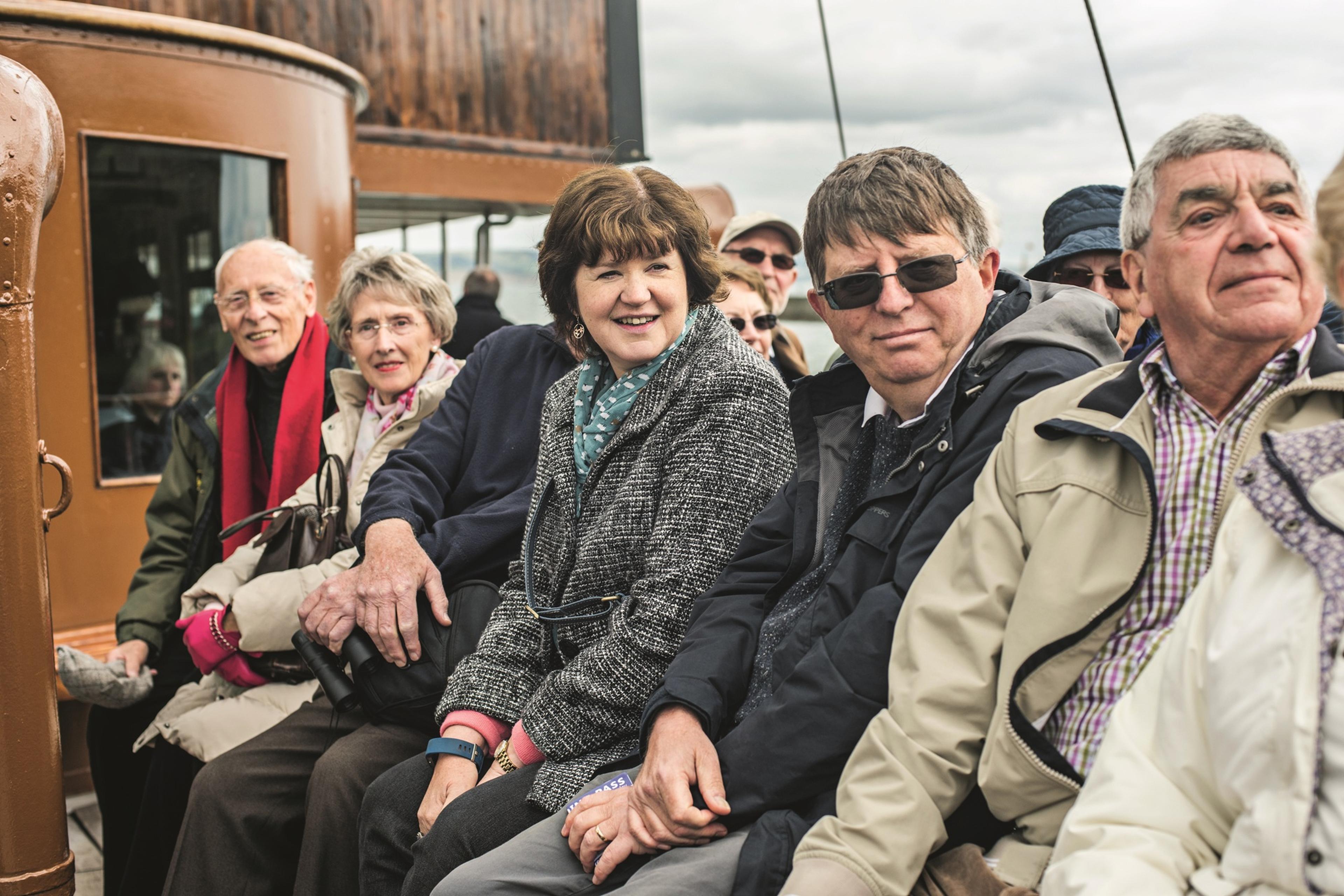 A group of Boundless members sitting closely on a boat