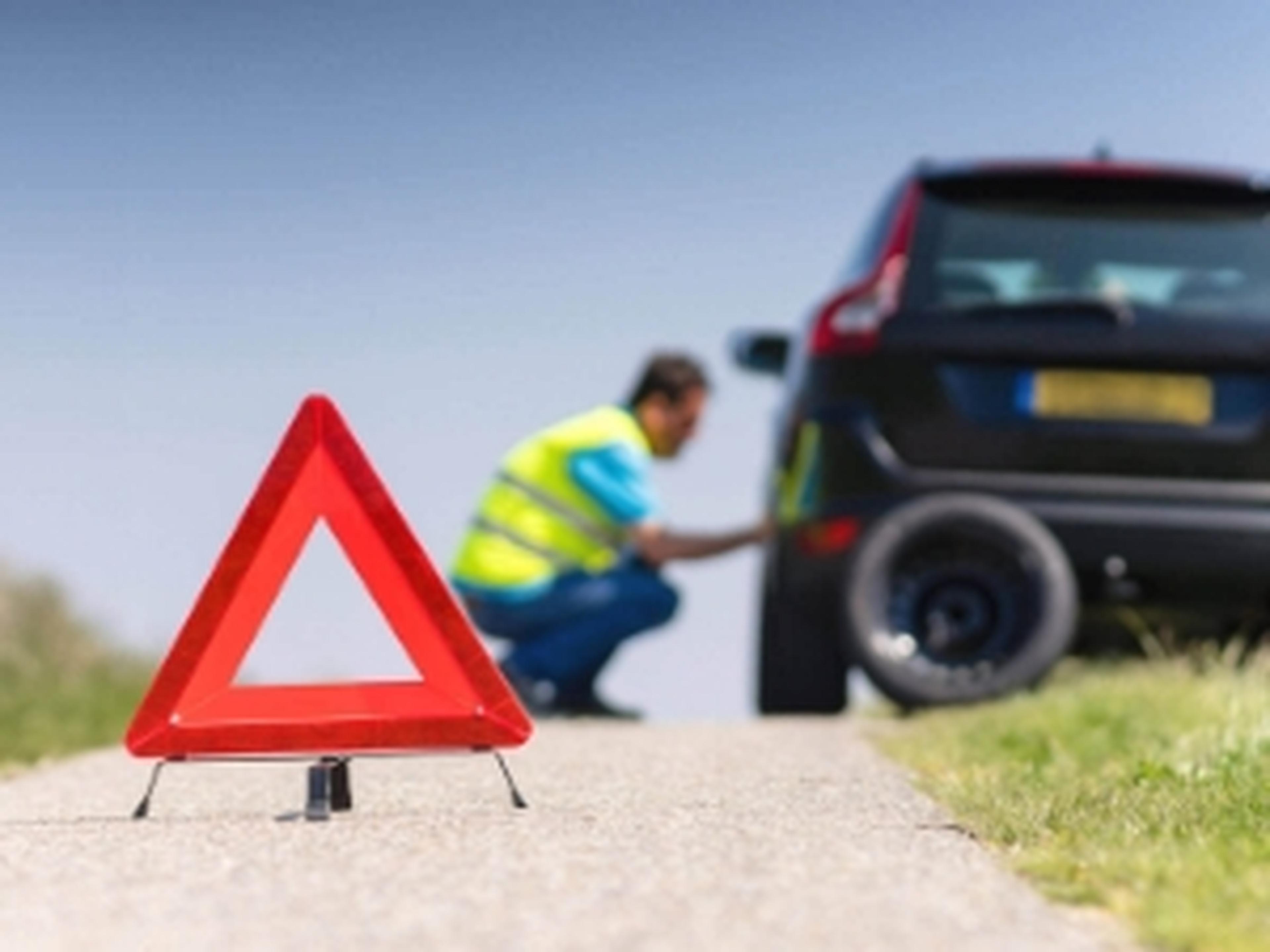 Man replacing a tyre at the roadside