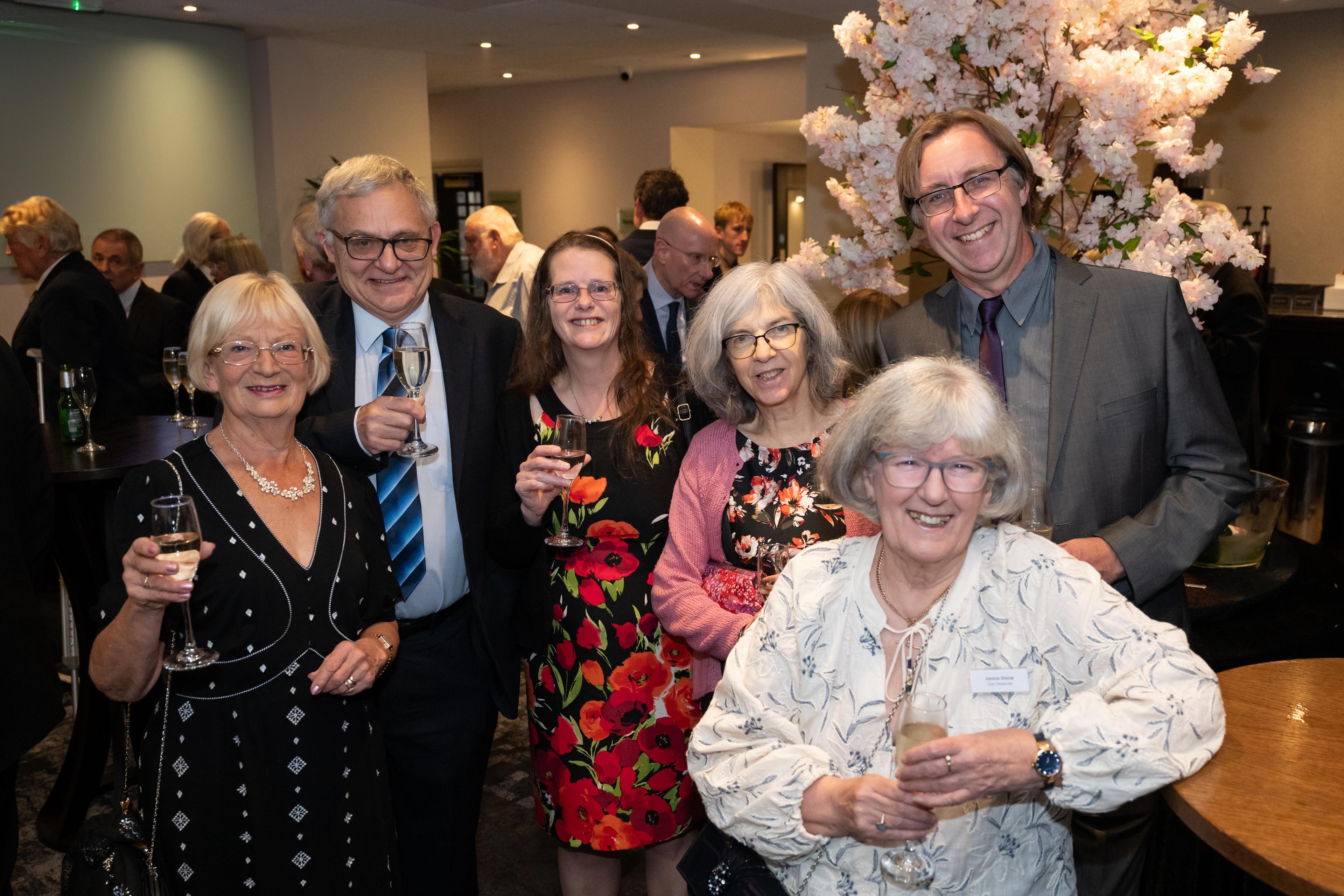 A group of six Boundless volunteers smiling and holding drinks at the Volunteer Recognition Awards 2025