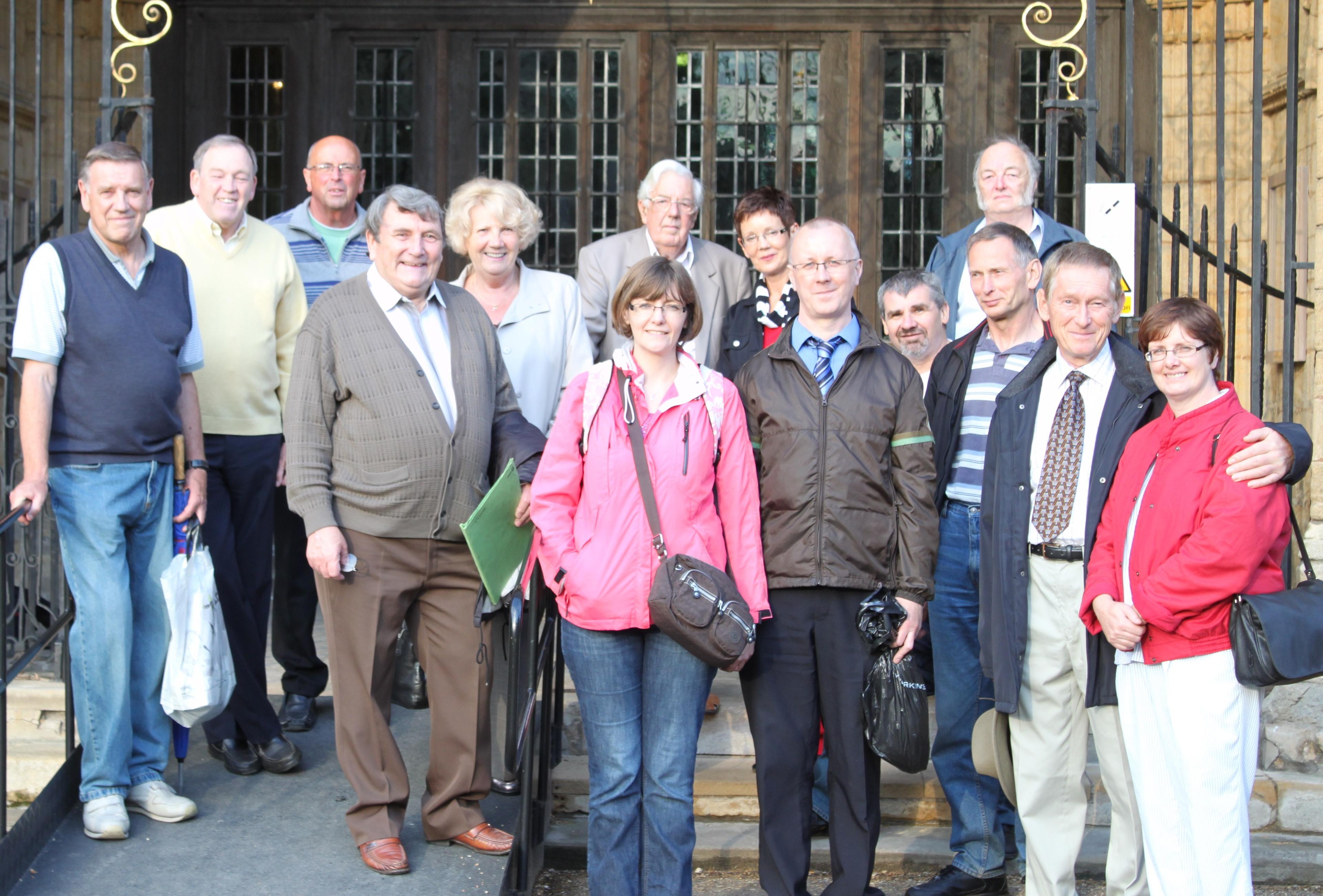 A group of people smiling and standing together on steps outside a building