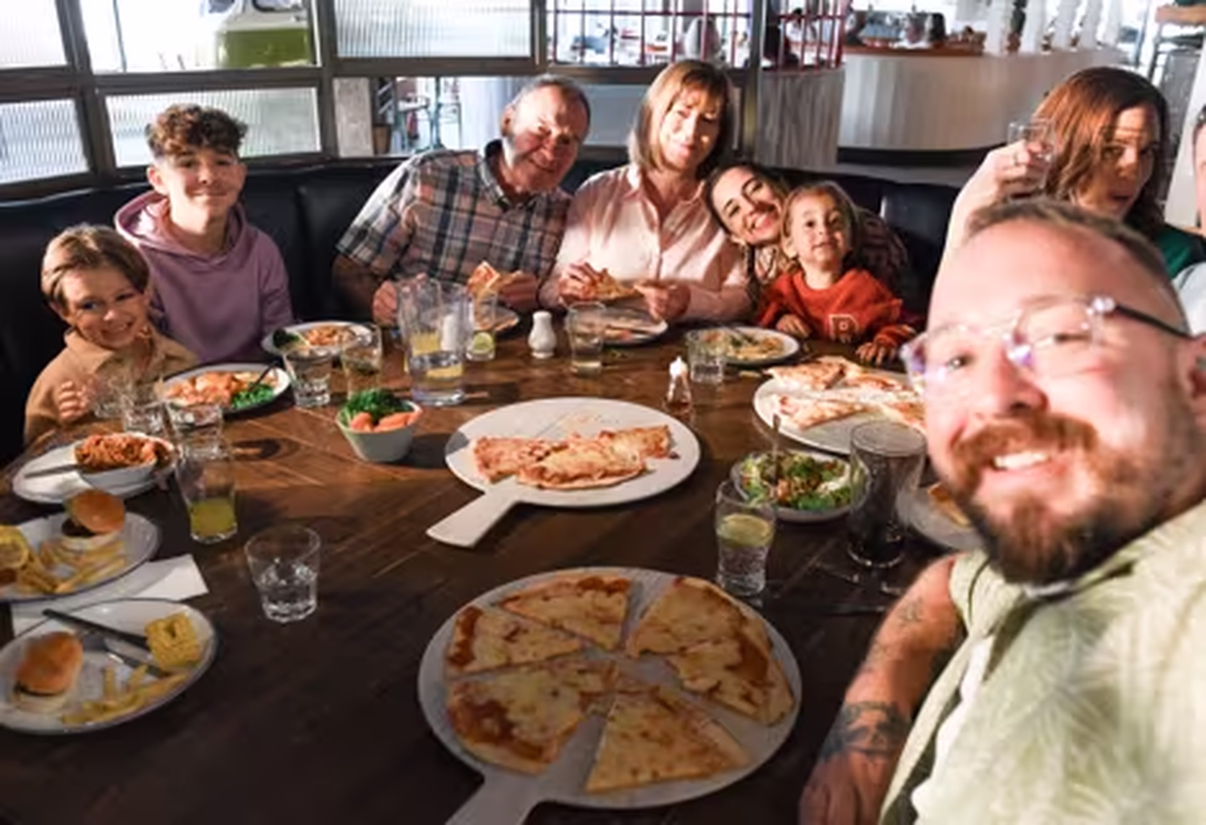 family at pizza restaurant smiling