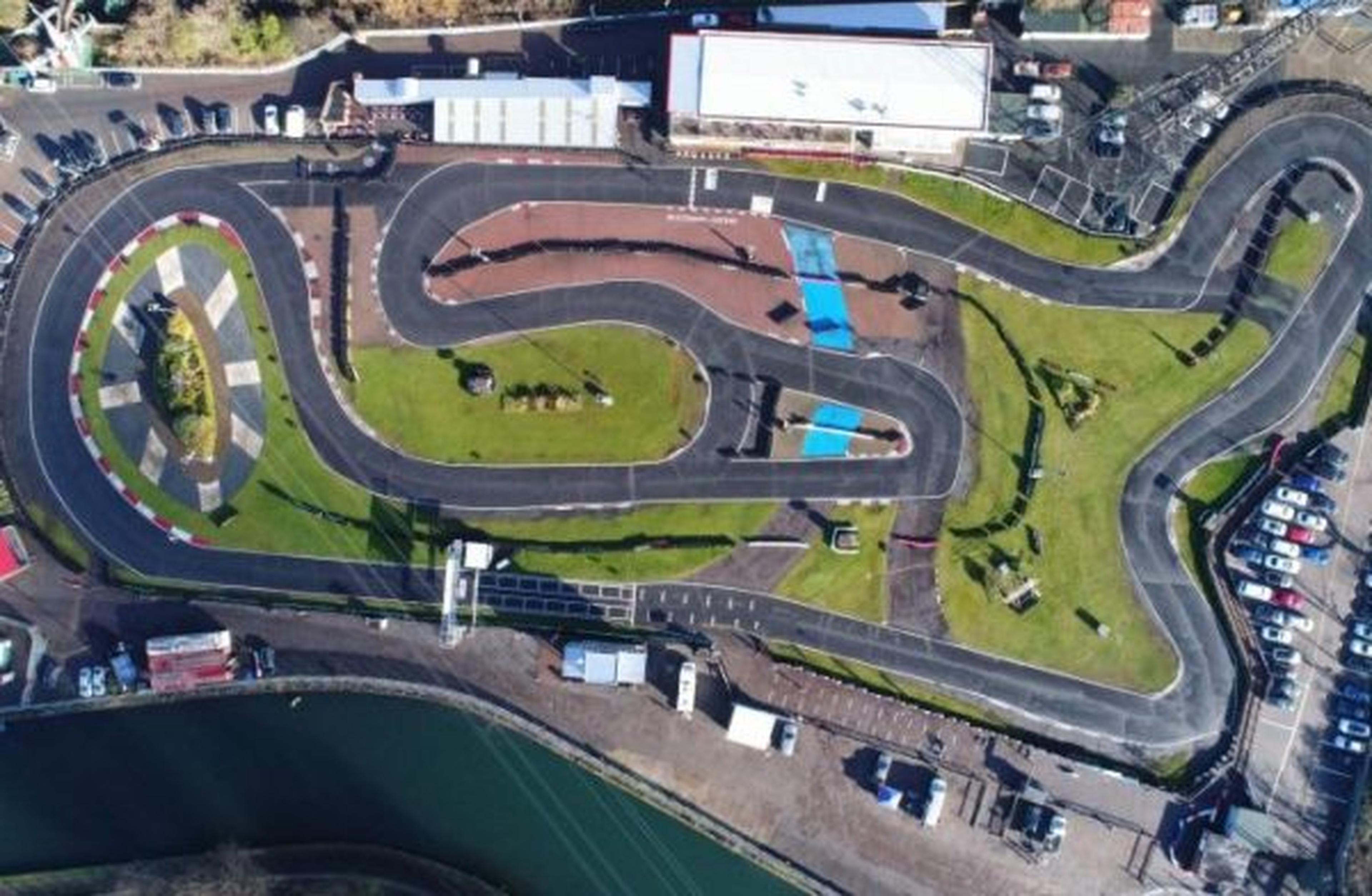Aerial view of a winding Rye House track with green areas and parked cars