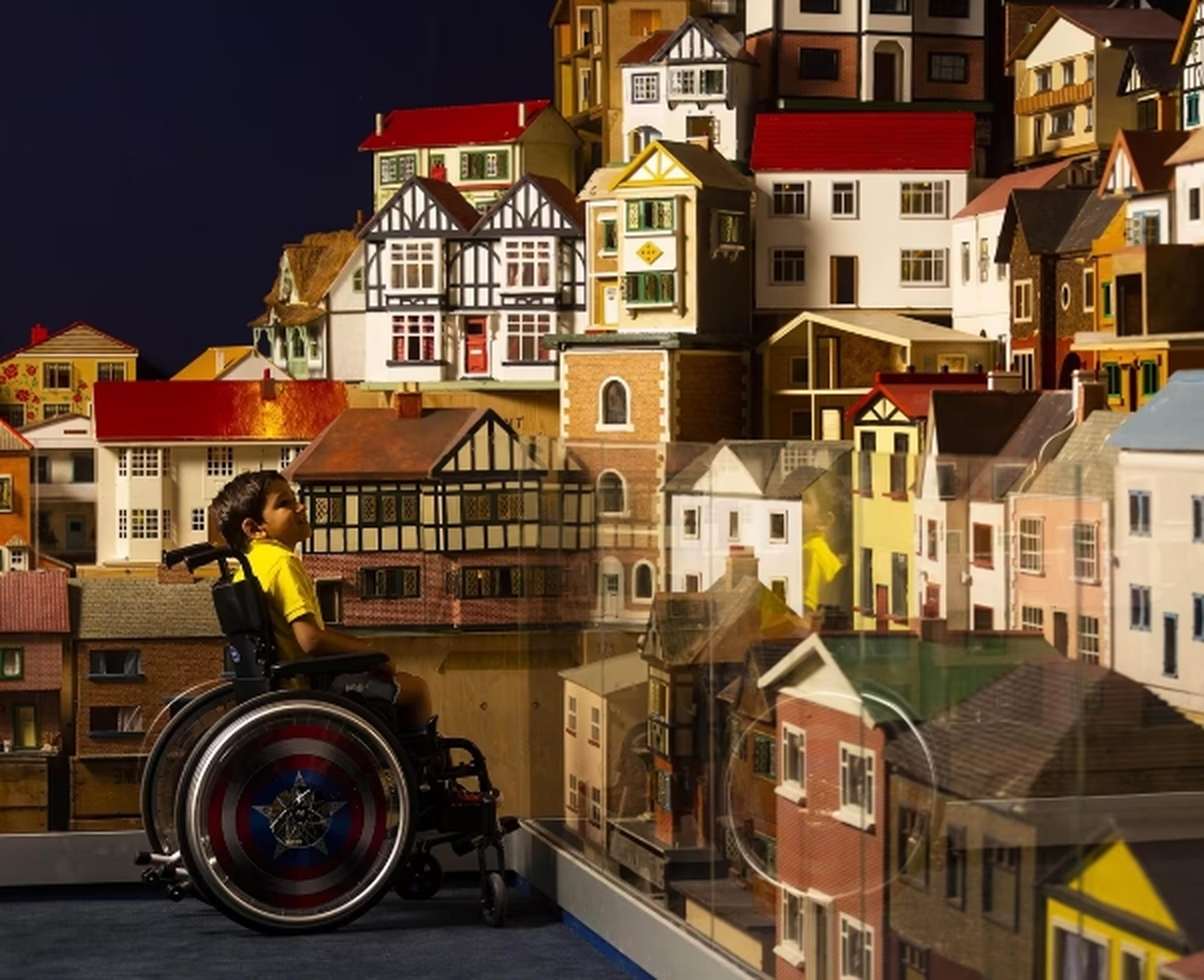Child in wheelchair looking at model houses