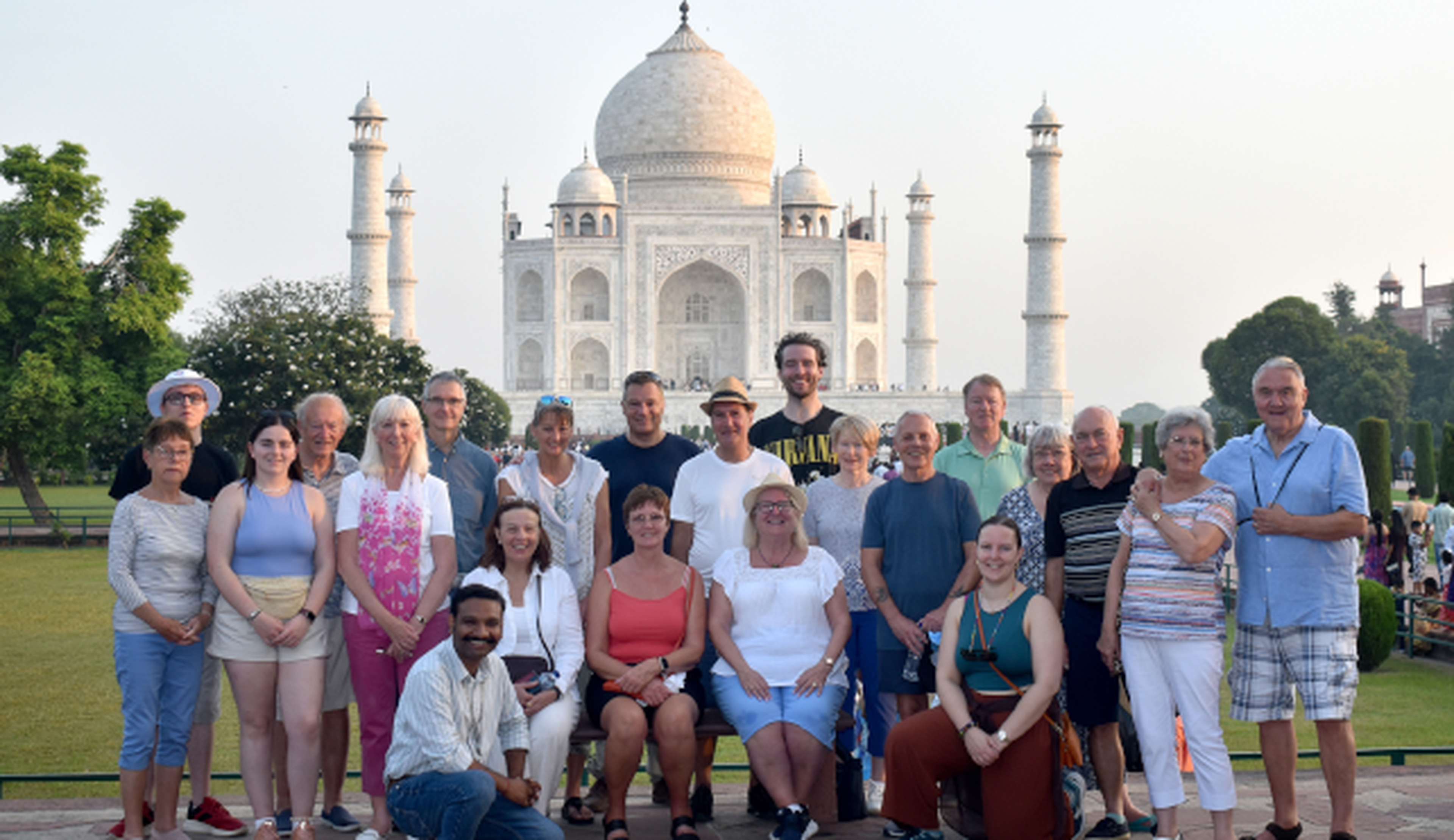 an image of a group tour standing outside the taj mahal