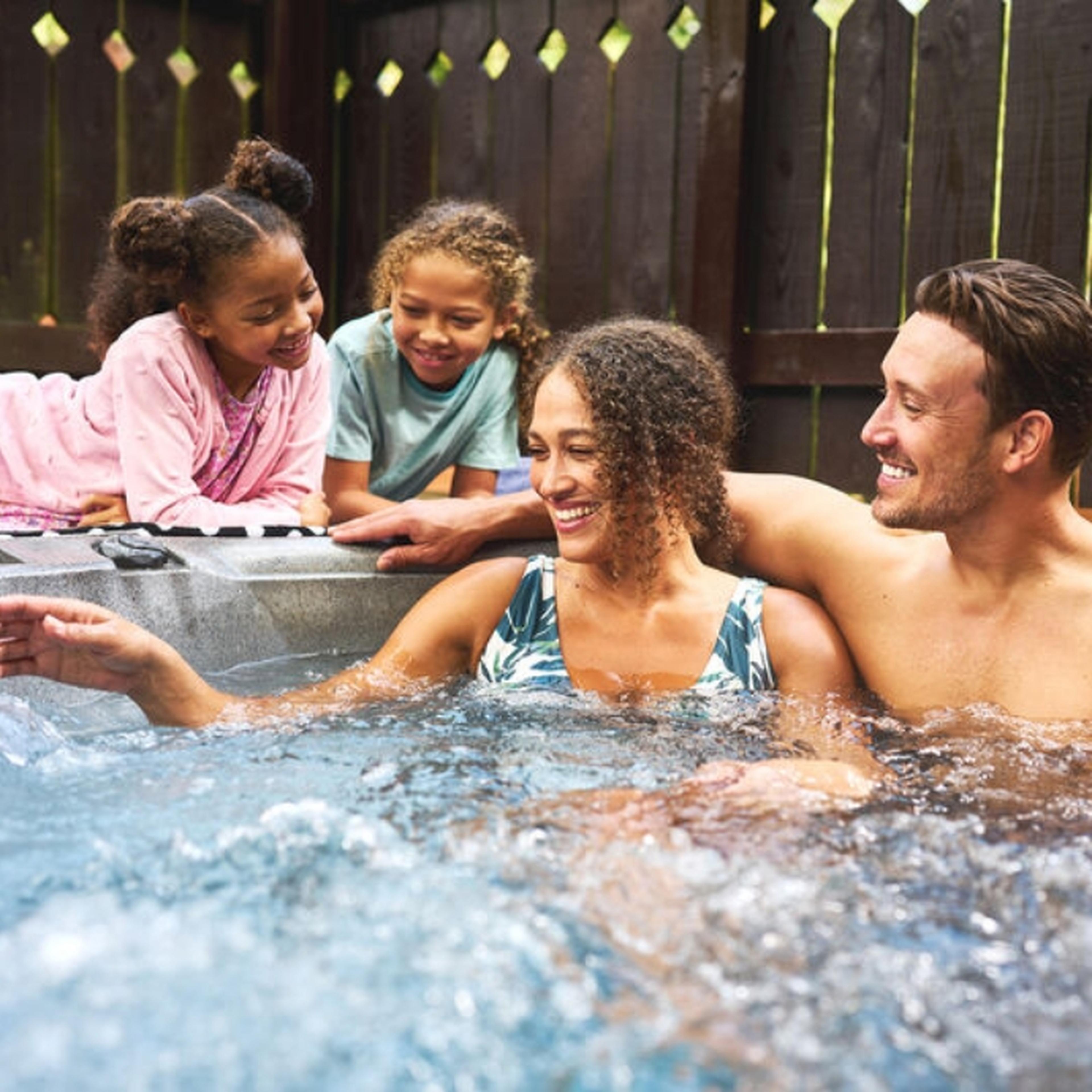 Family relaxing in a hot tub at Whitemead Forest Park