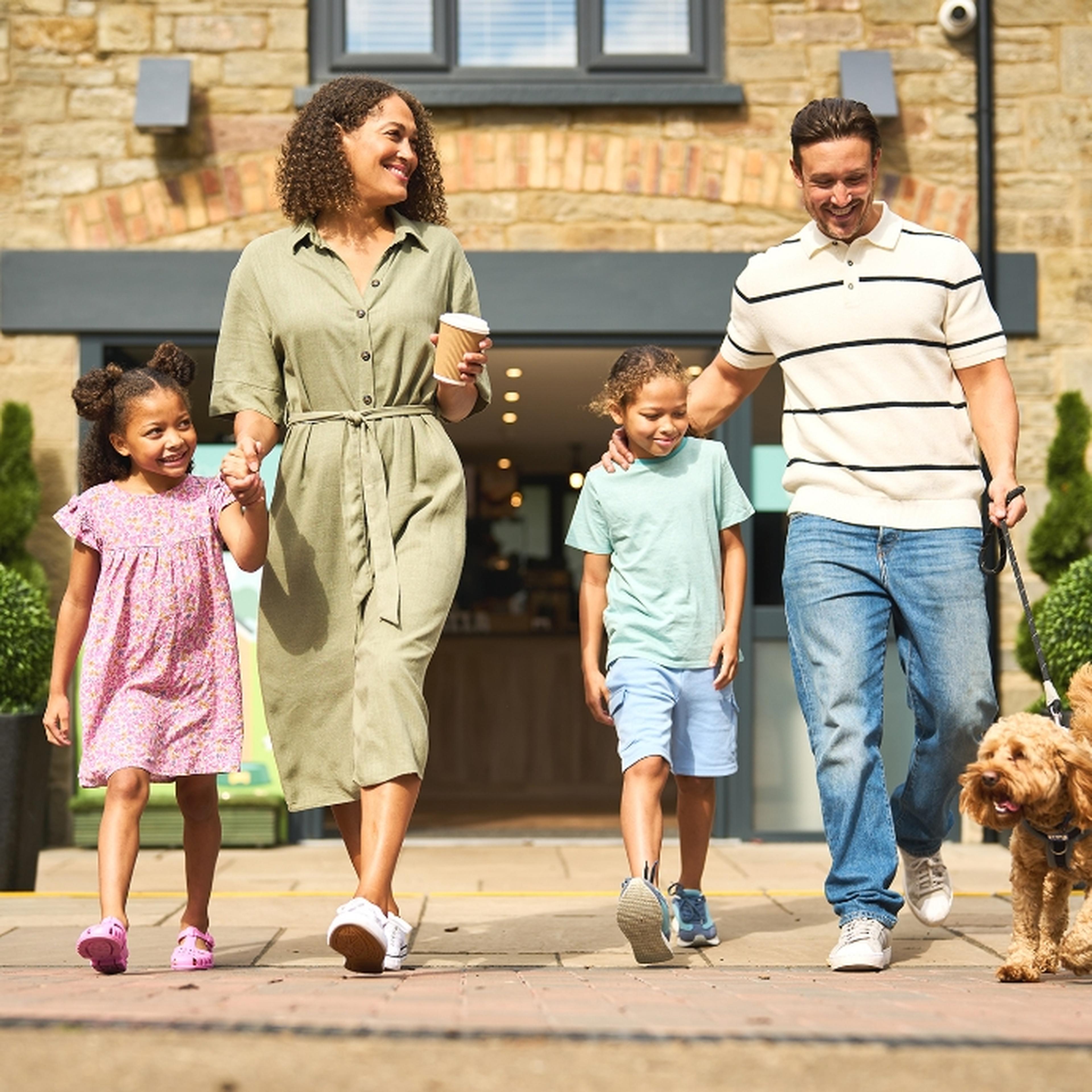 Family walking outside Whitemead Forest Park Café with dog