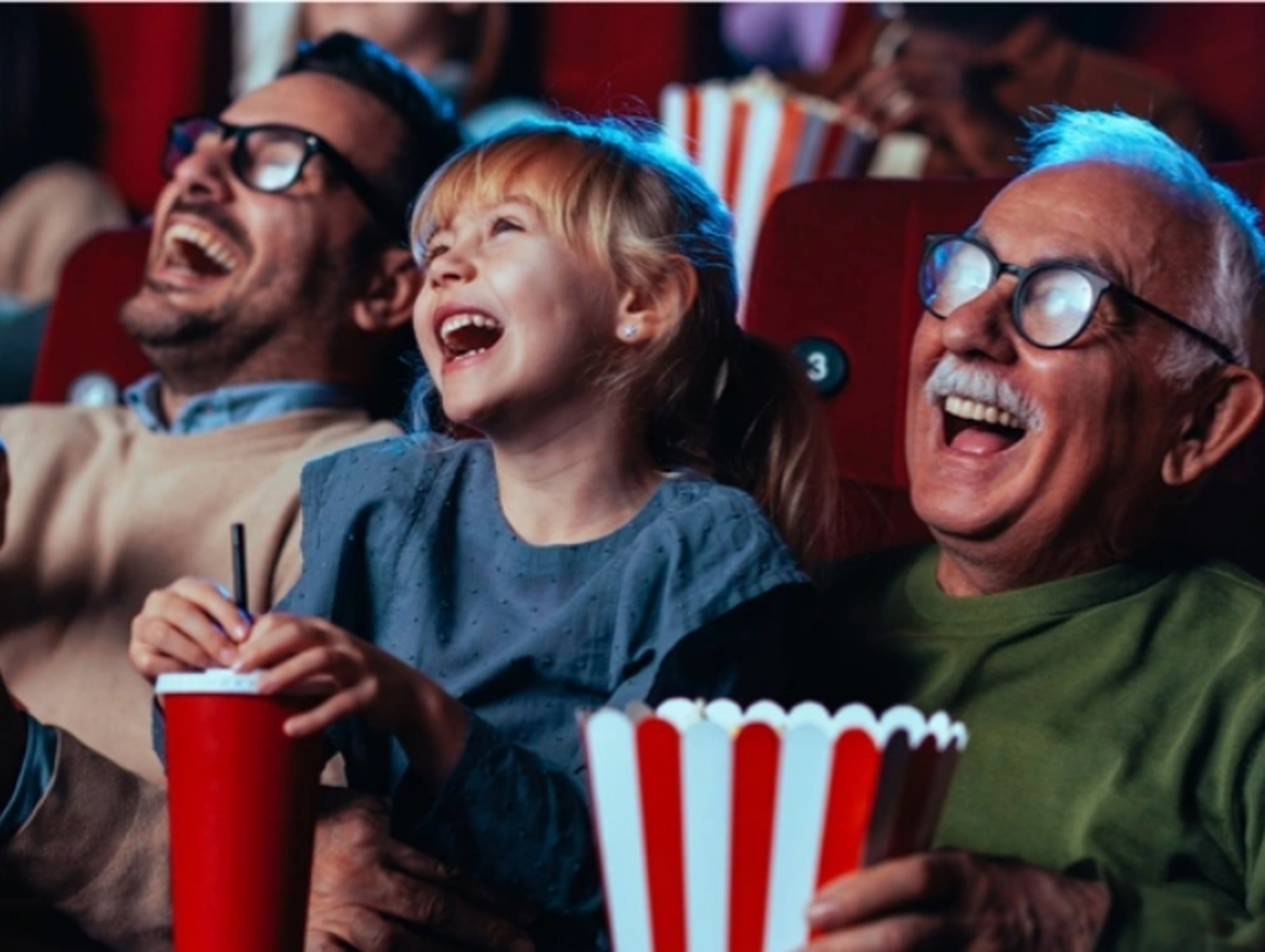 Man and child watching a film at the cinema