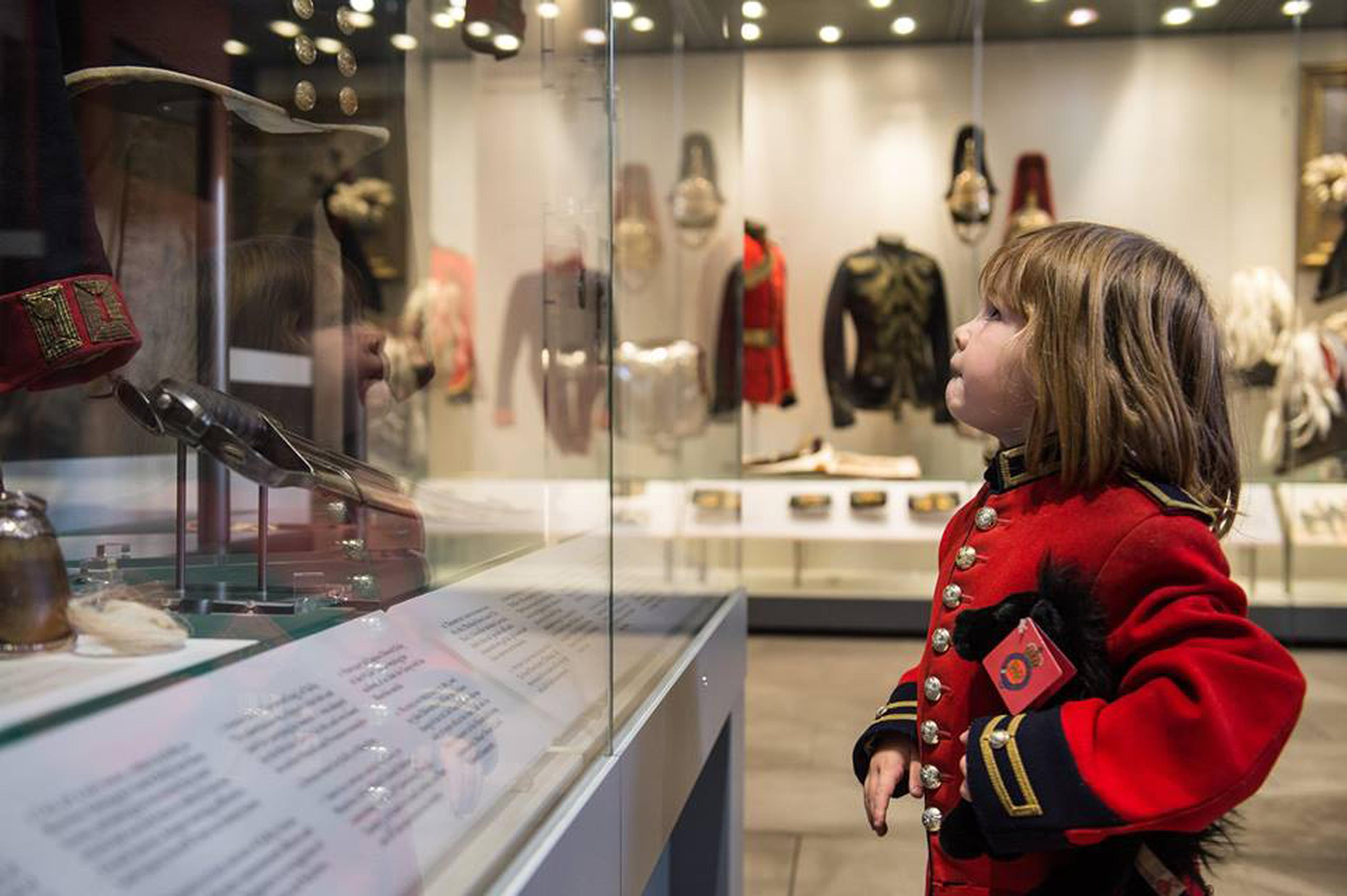 Little boy admiring a display at a museum.