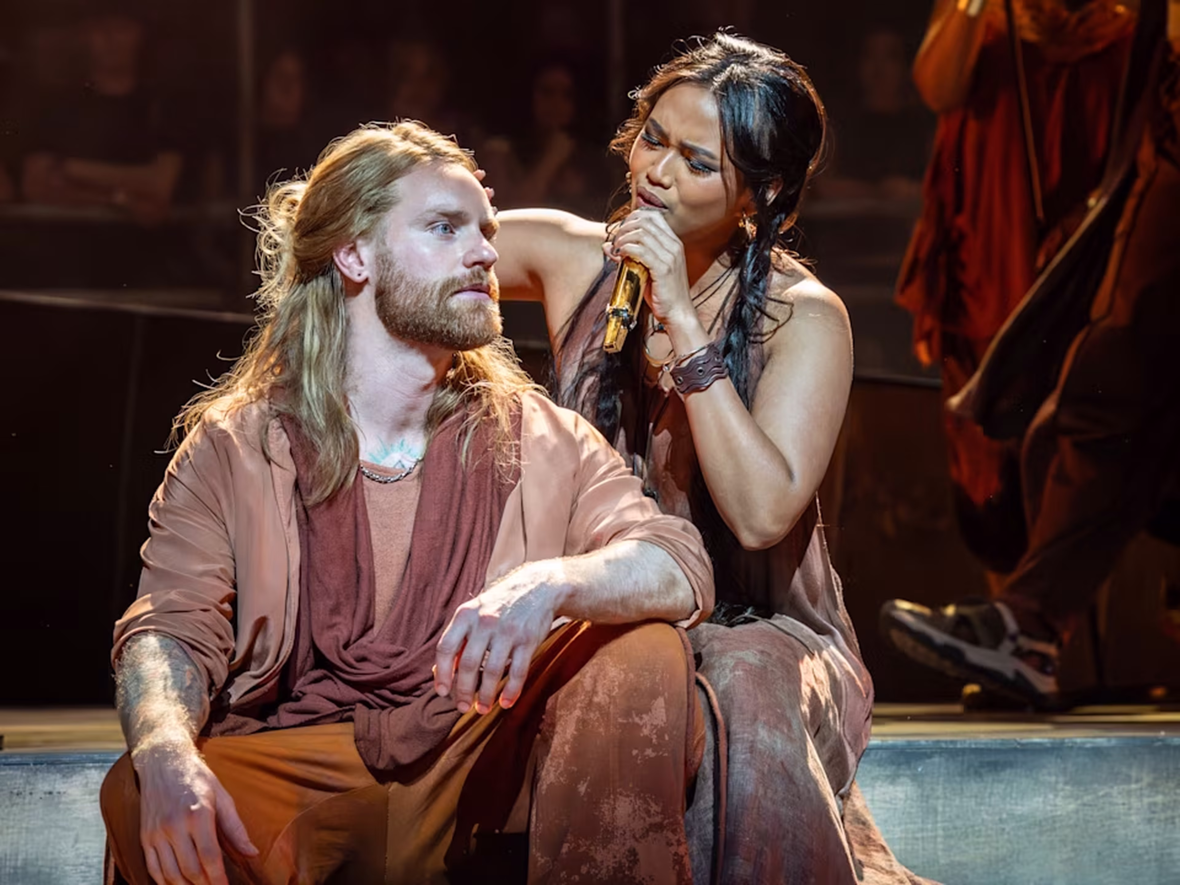 This photograph captures a scene from the rock opera Jesus Christ Superstar, showing two performers in period costumes during a dramatic moment on stage. The production is known for its powerful storytelling and theatrical staging, bringing the biblical story to life with music and performance art.