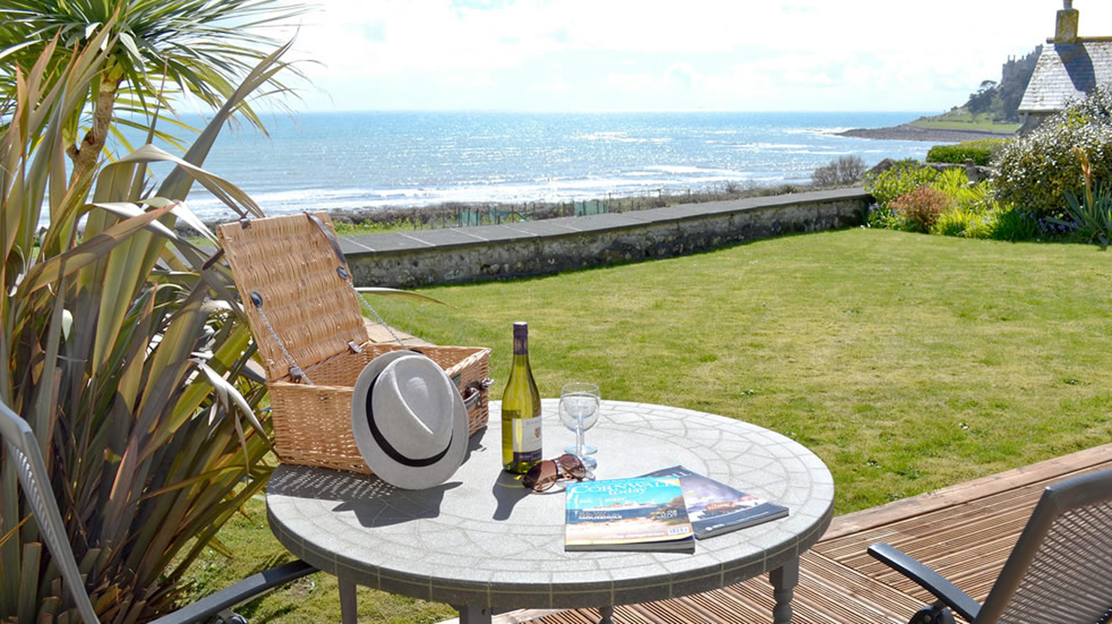 Table and chairs on a decking looking over ocean