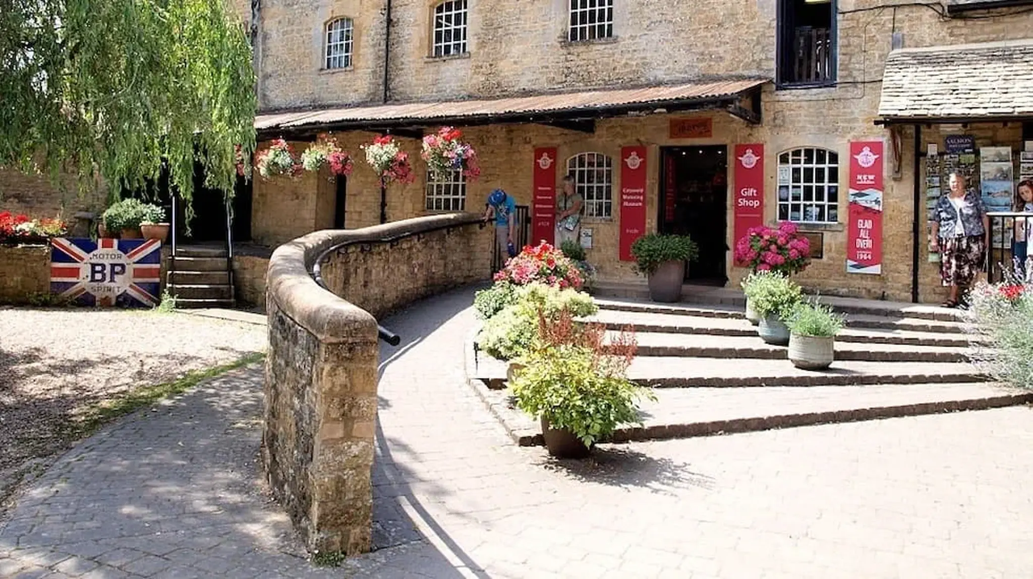 Charming stone building with gift shop, red signs, and flower decorations