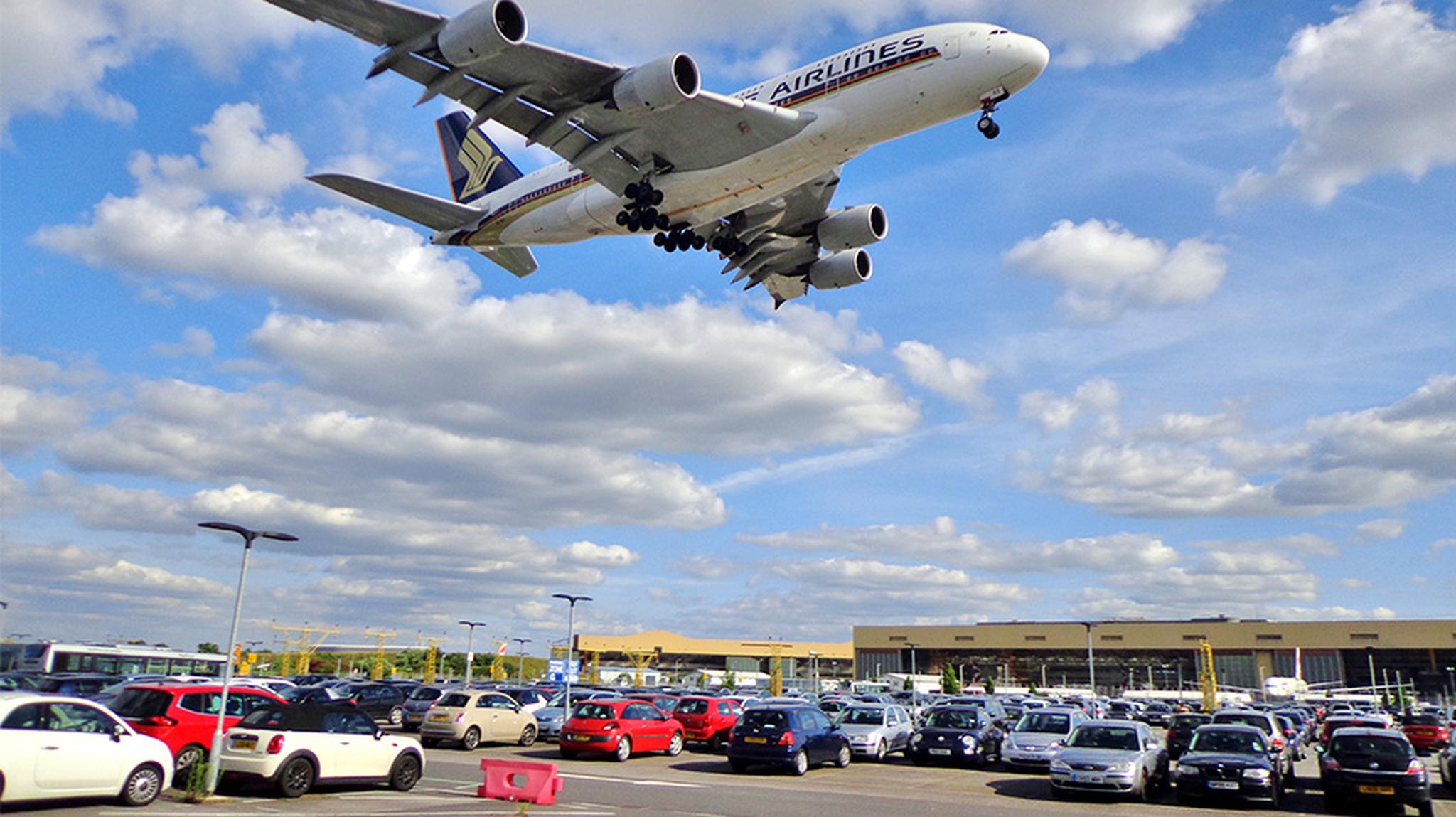 Airplane in sky above car park