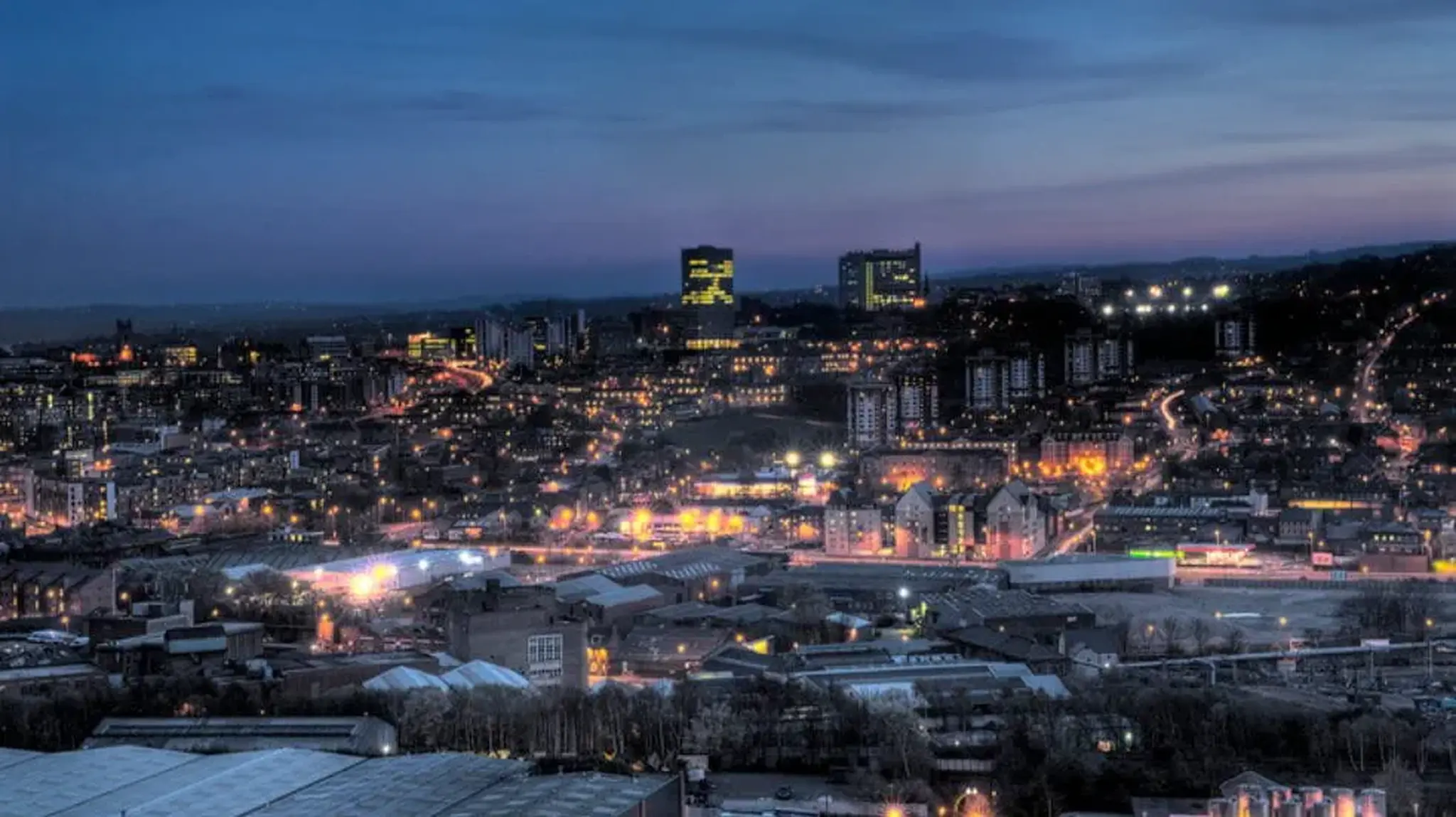 Sheffield cityscape at dusk with illuminated buildings and streets