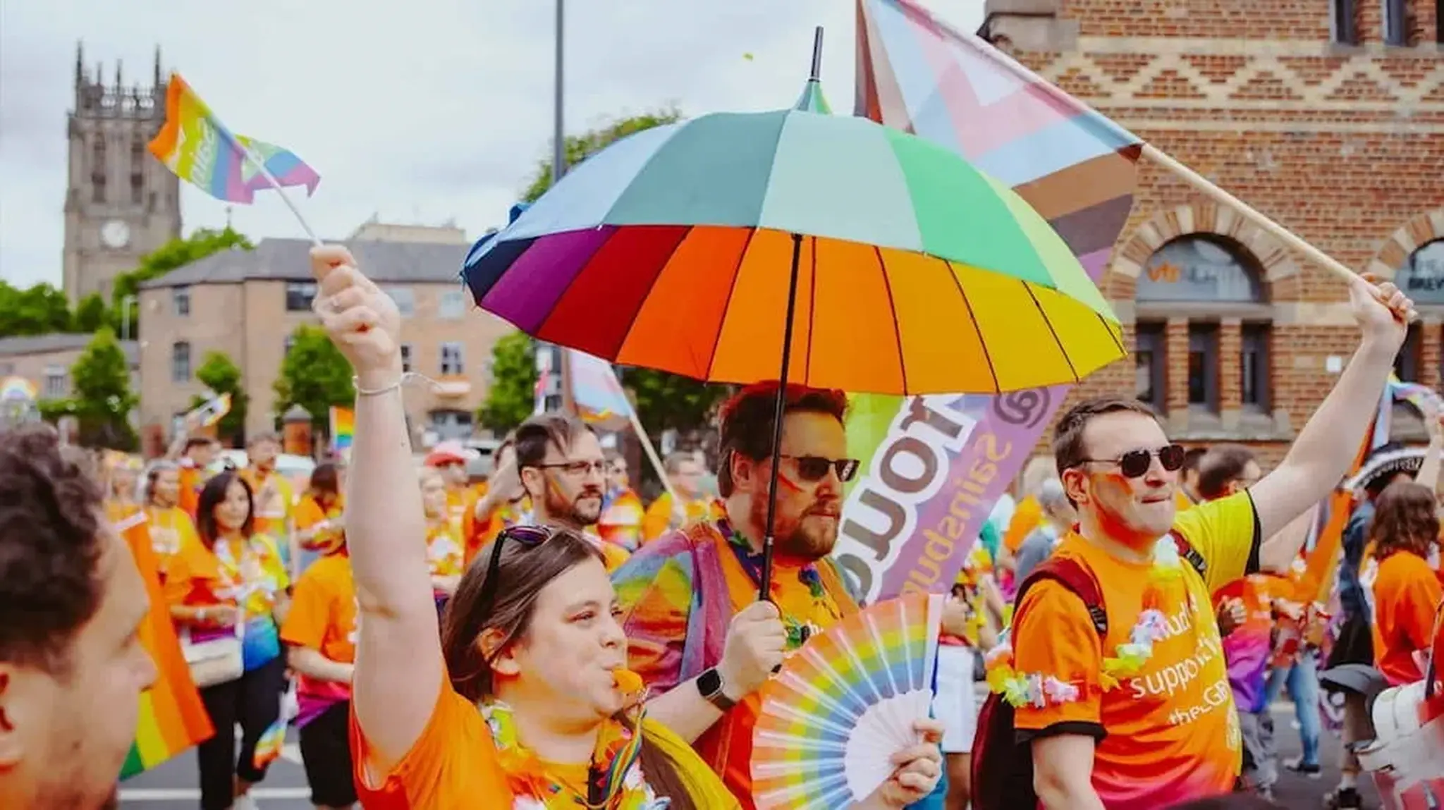 People in colourful attire participate in a pride parade