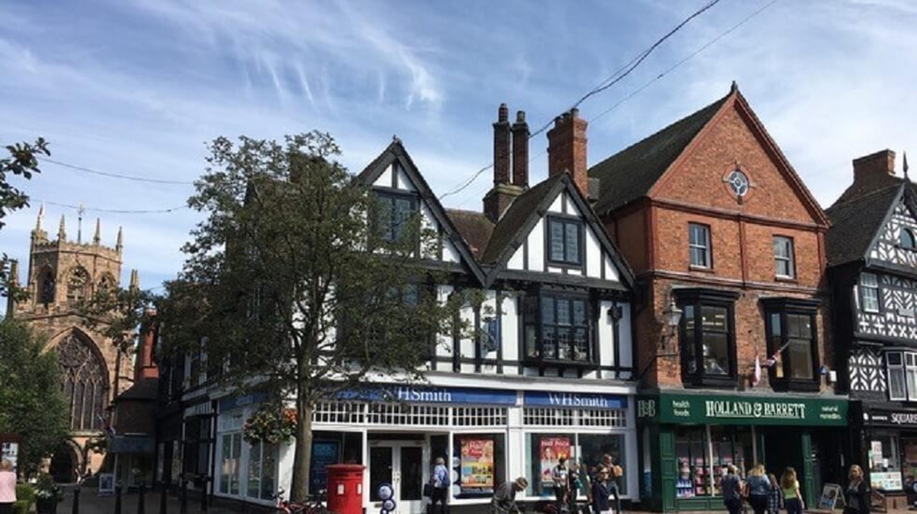 Street view of traditional English buildings, including shops