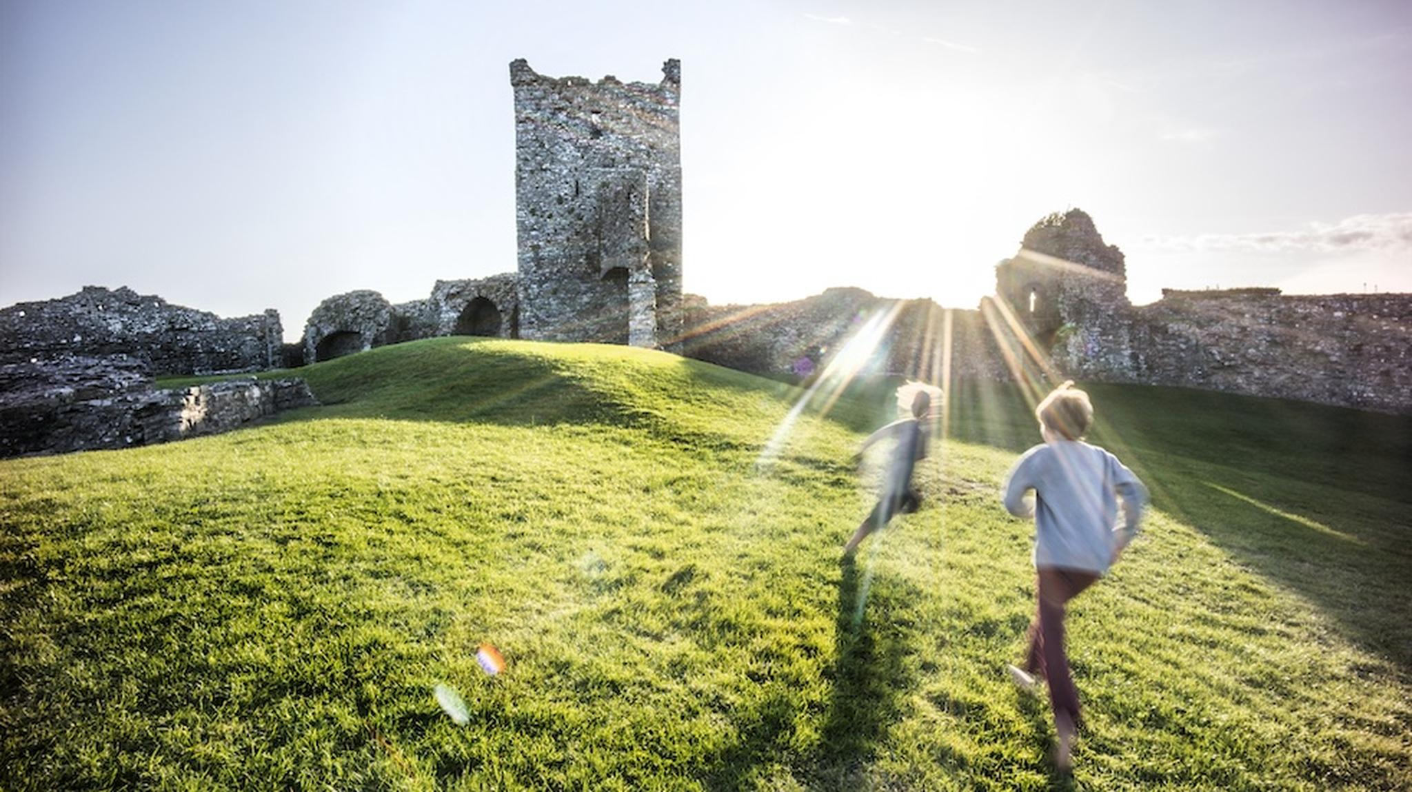 2 children running outside castle