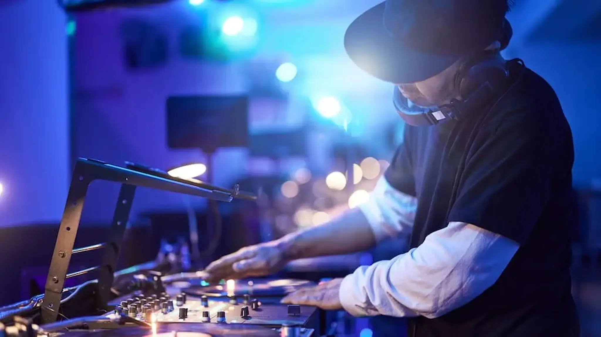 DJ mixing music on turntables in a dimly lit club