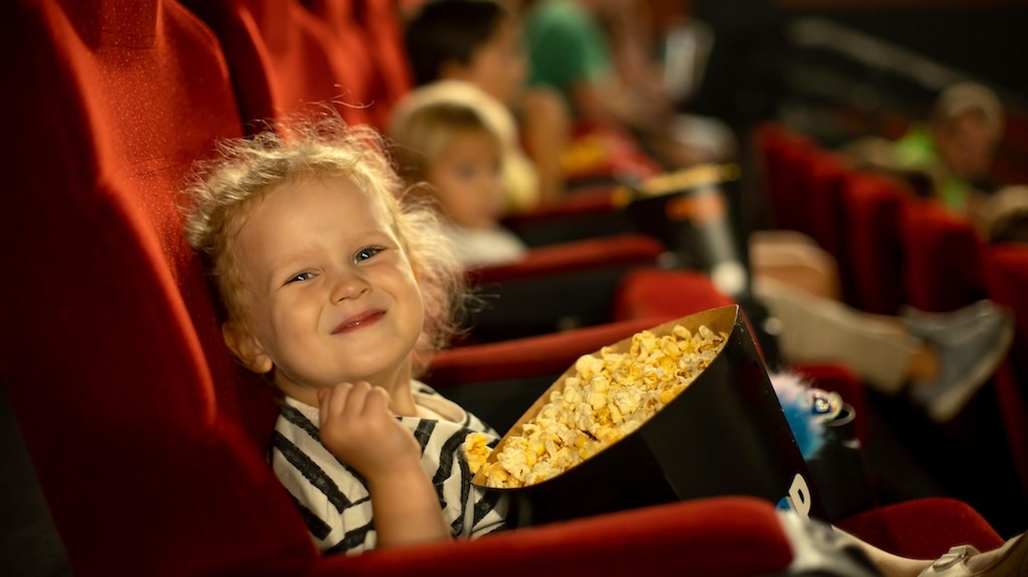 Little girl with popcorn smiling at camera
