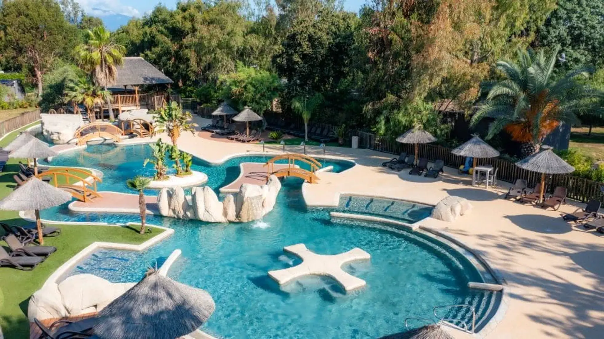 Aerial view of a tropical resort pool area with multiple pools