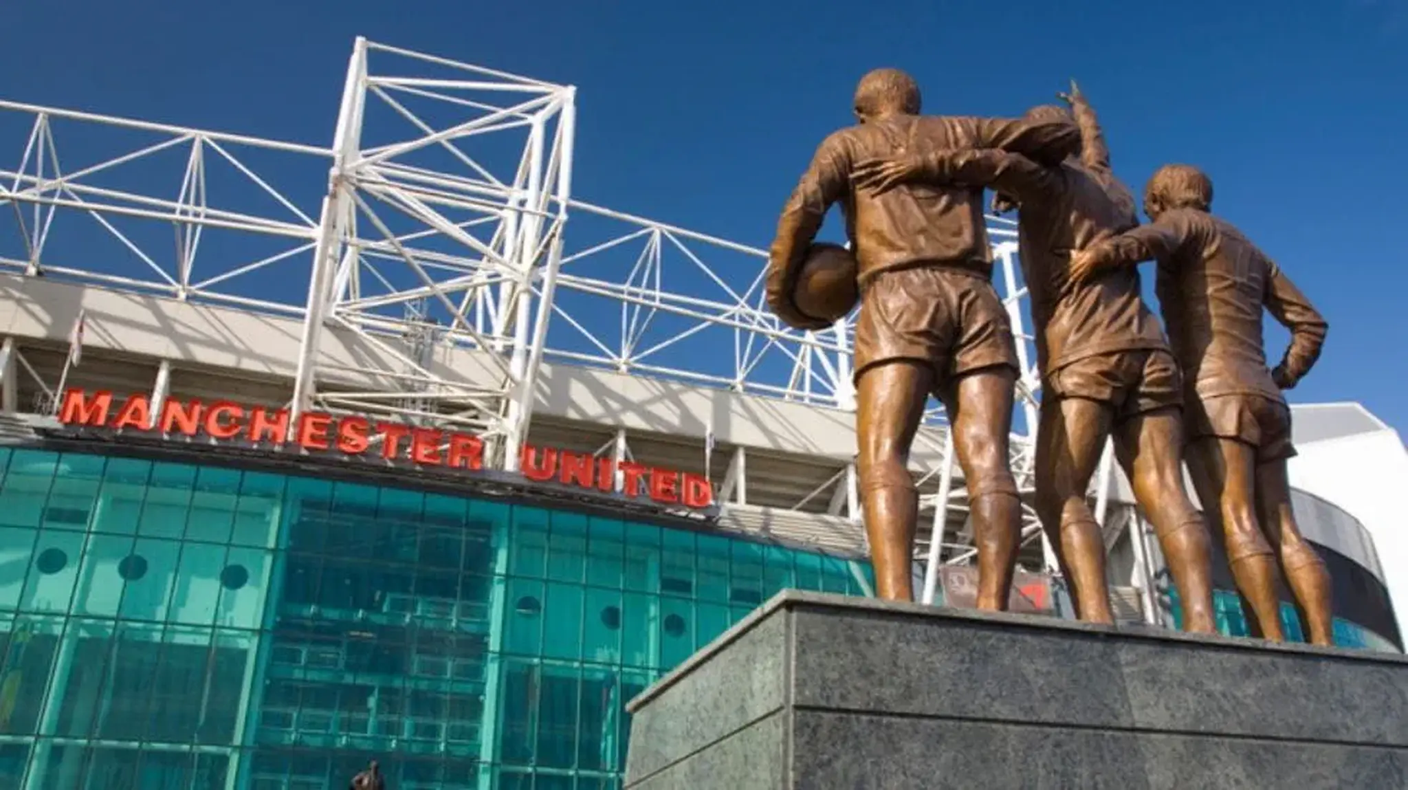 Statue of three football players in front of Old Trafford Stadium, Manchester United