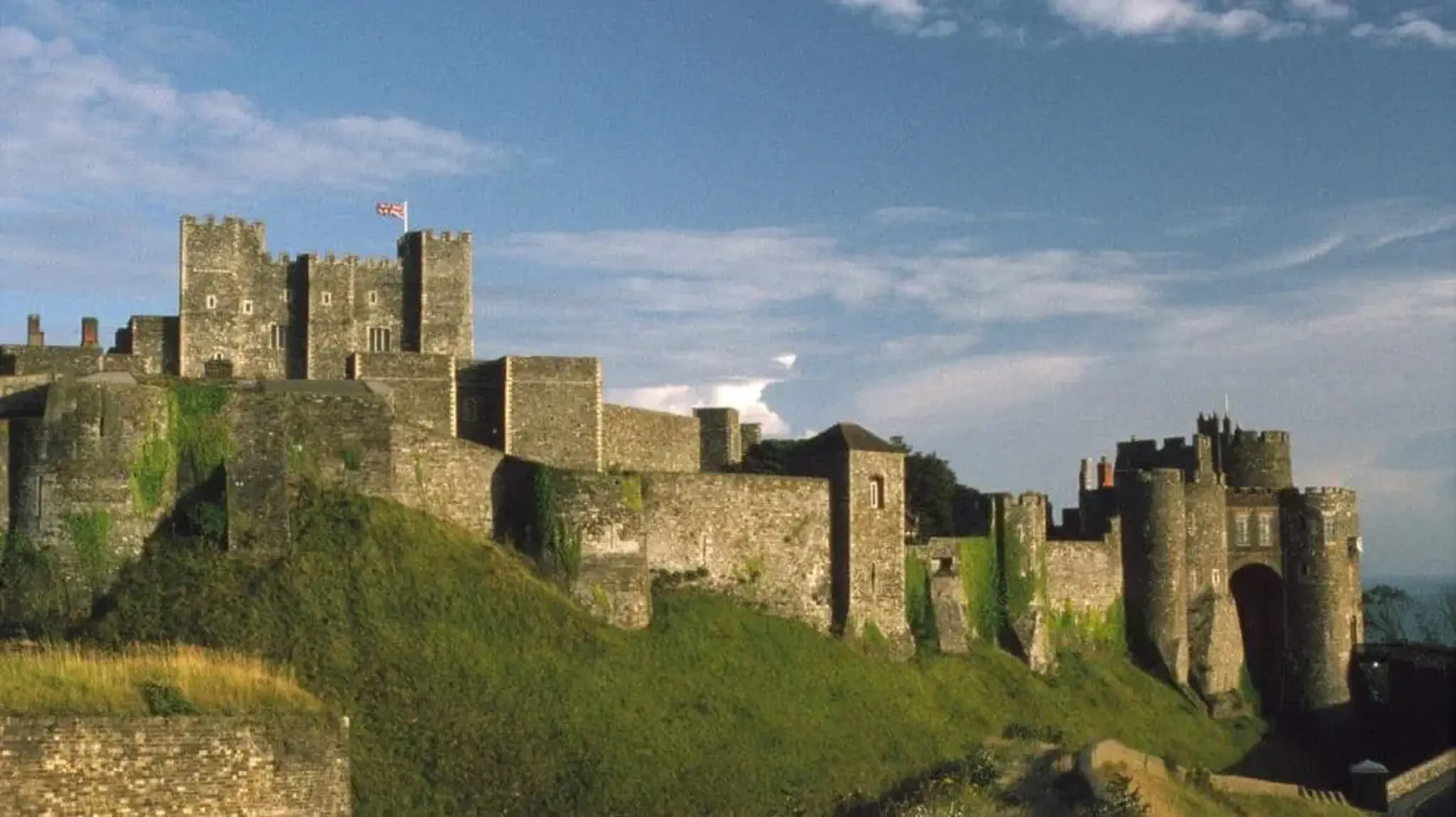 Historic Dover Castle with stone walls and turrets on a grassy hill