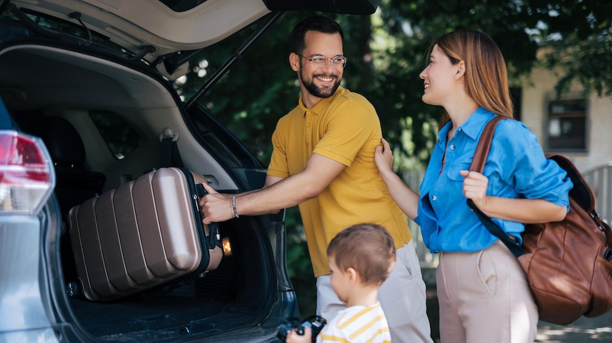 Family of 3 filling a car boot