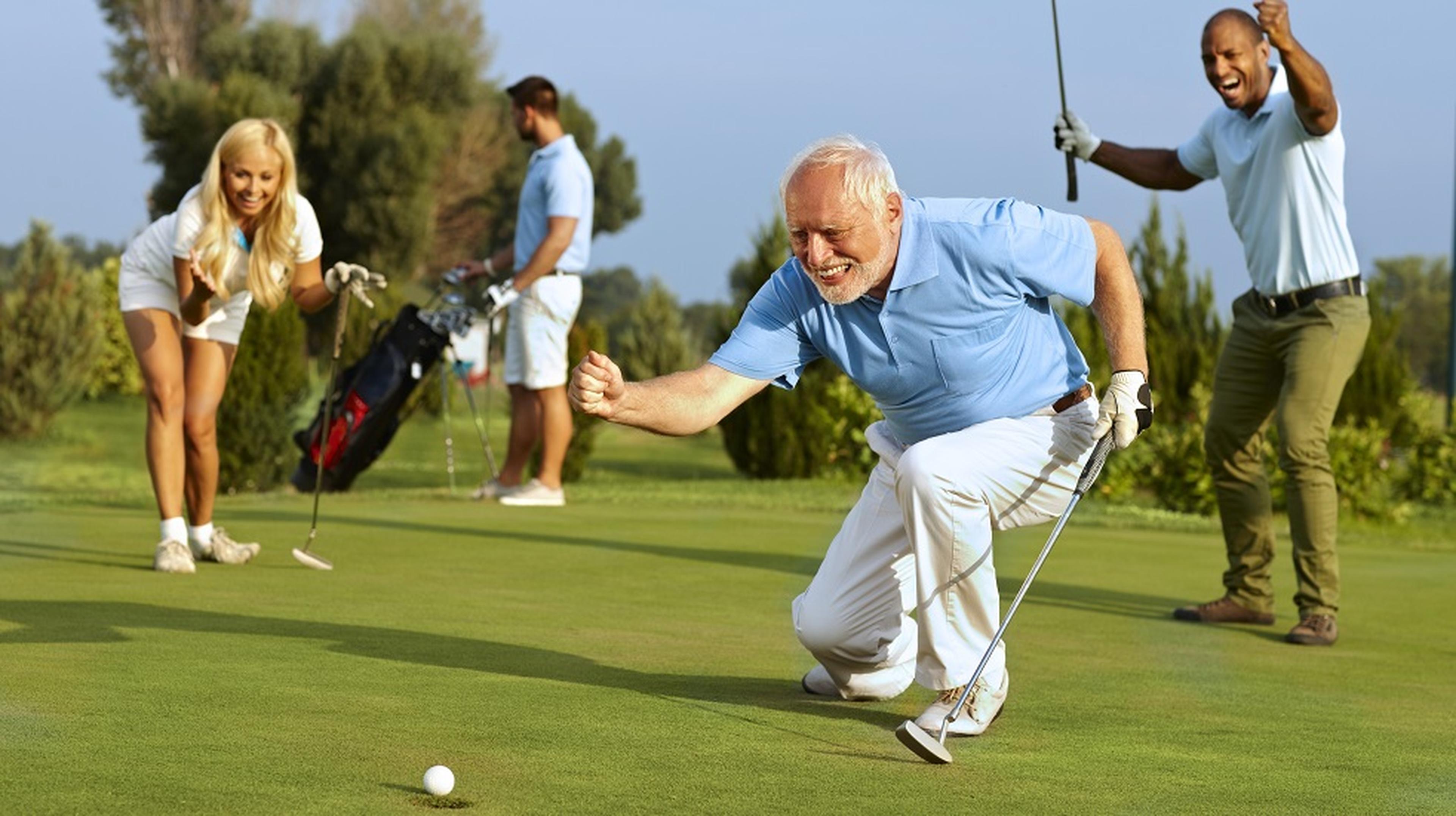 A joyful golfer celebrates a successful putt, kneeling on the green