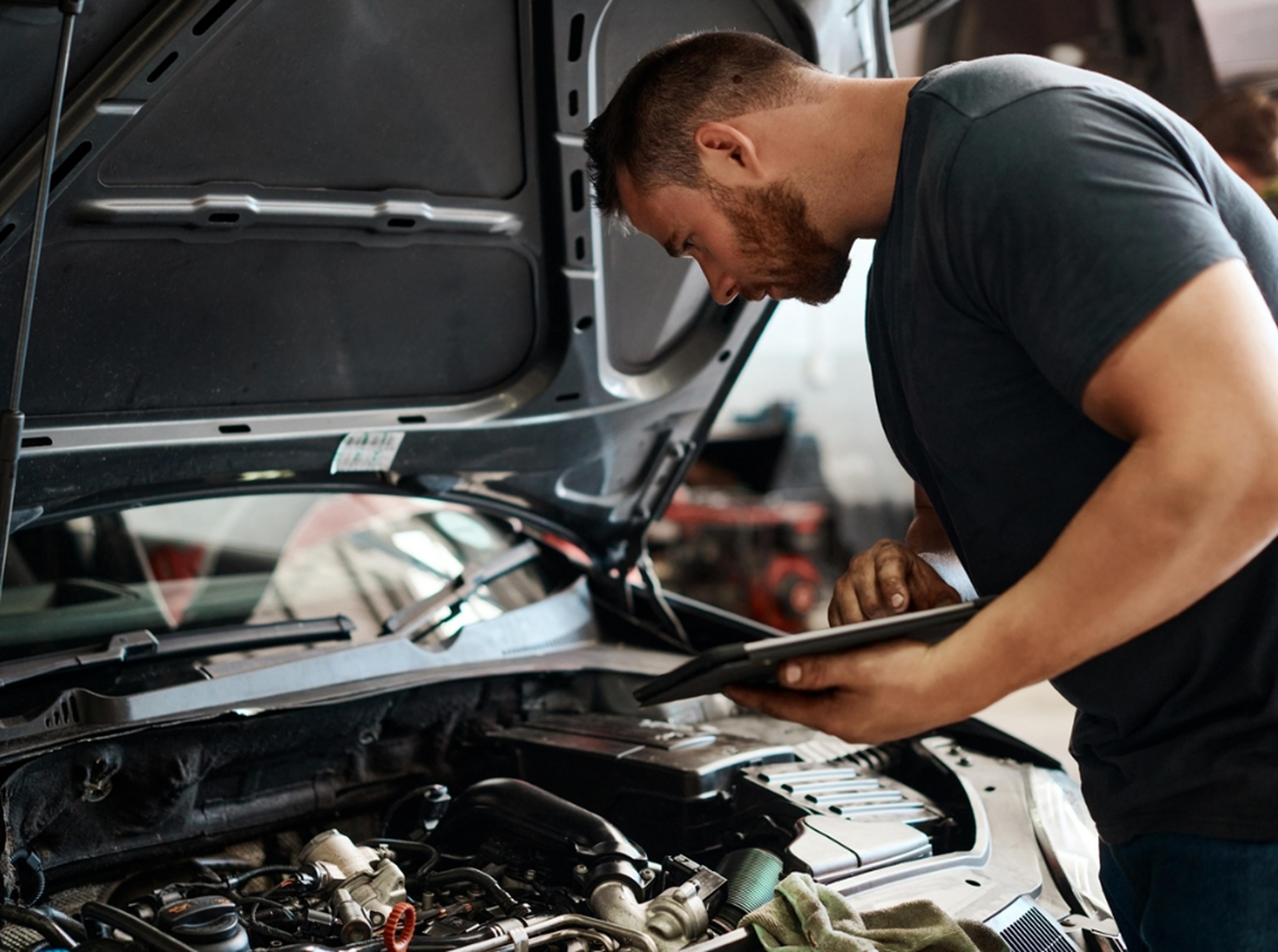 an image of a man looking at a car engine