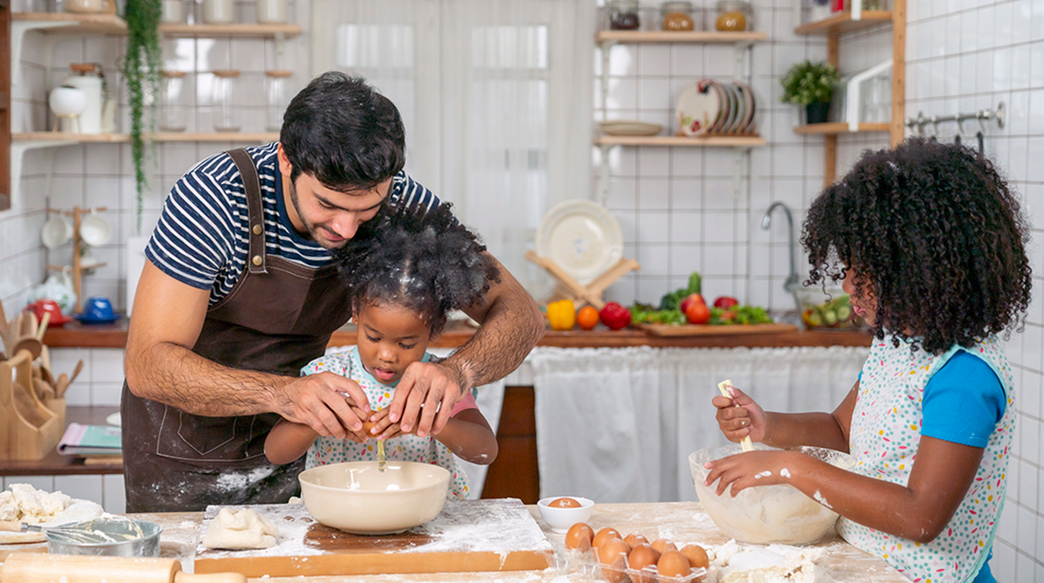 Father and his two daughters baking in the kitchen together
