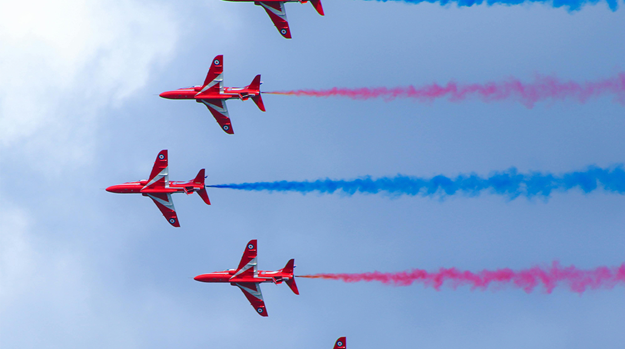 Red Arrows flying across a blue sky