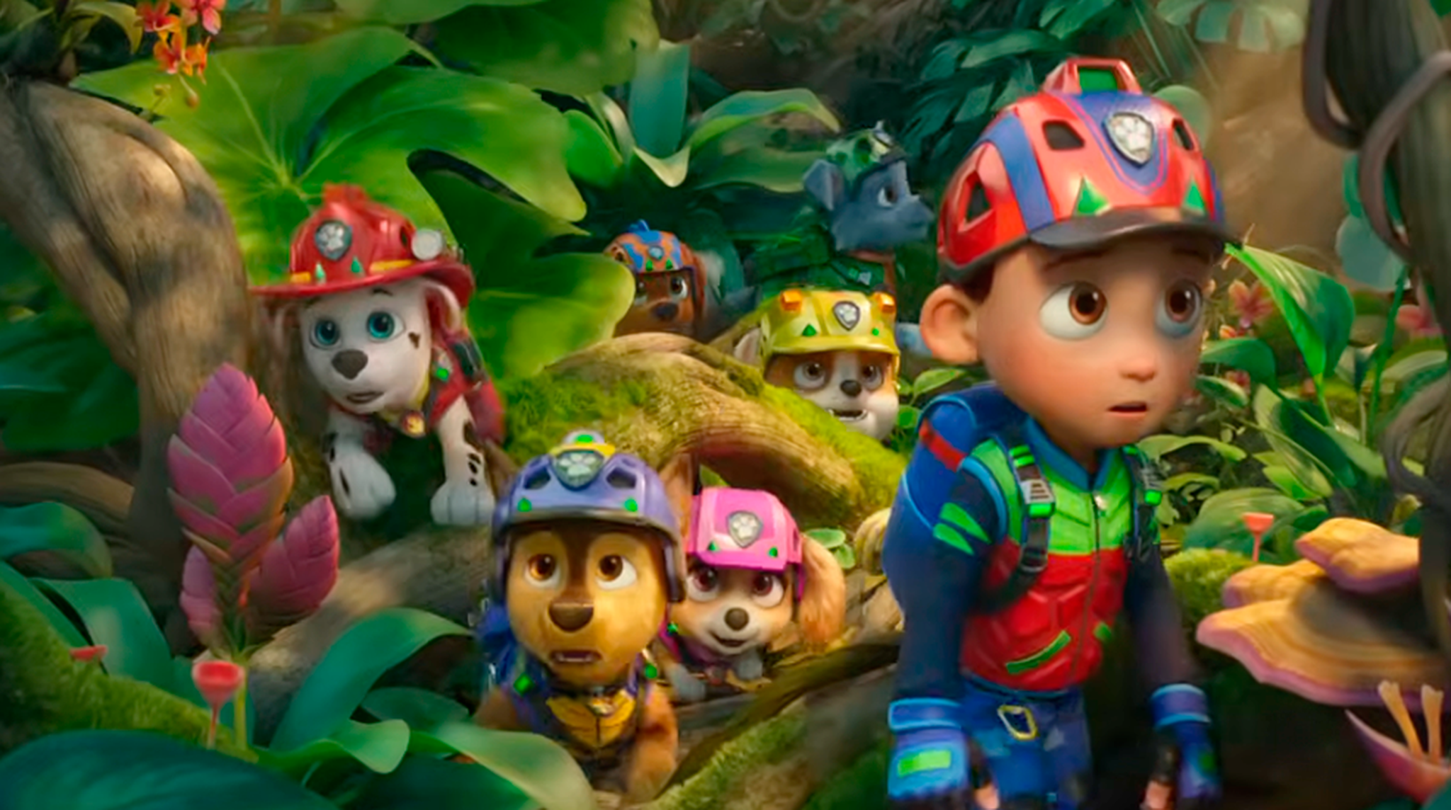 An adventurous boy with a helmet leads a group of cartoon puppies through a colorful jungle filled with lush green foliage and vibrant flowers.