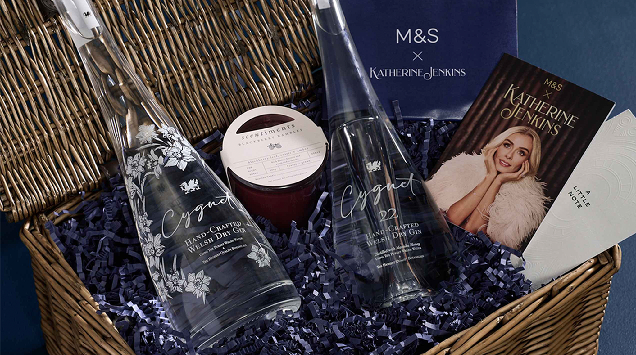 Gift hamper with two bottles of gin, a candle, and Katherine Jenkins booklet