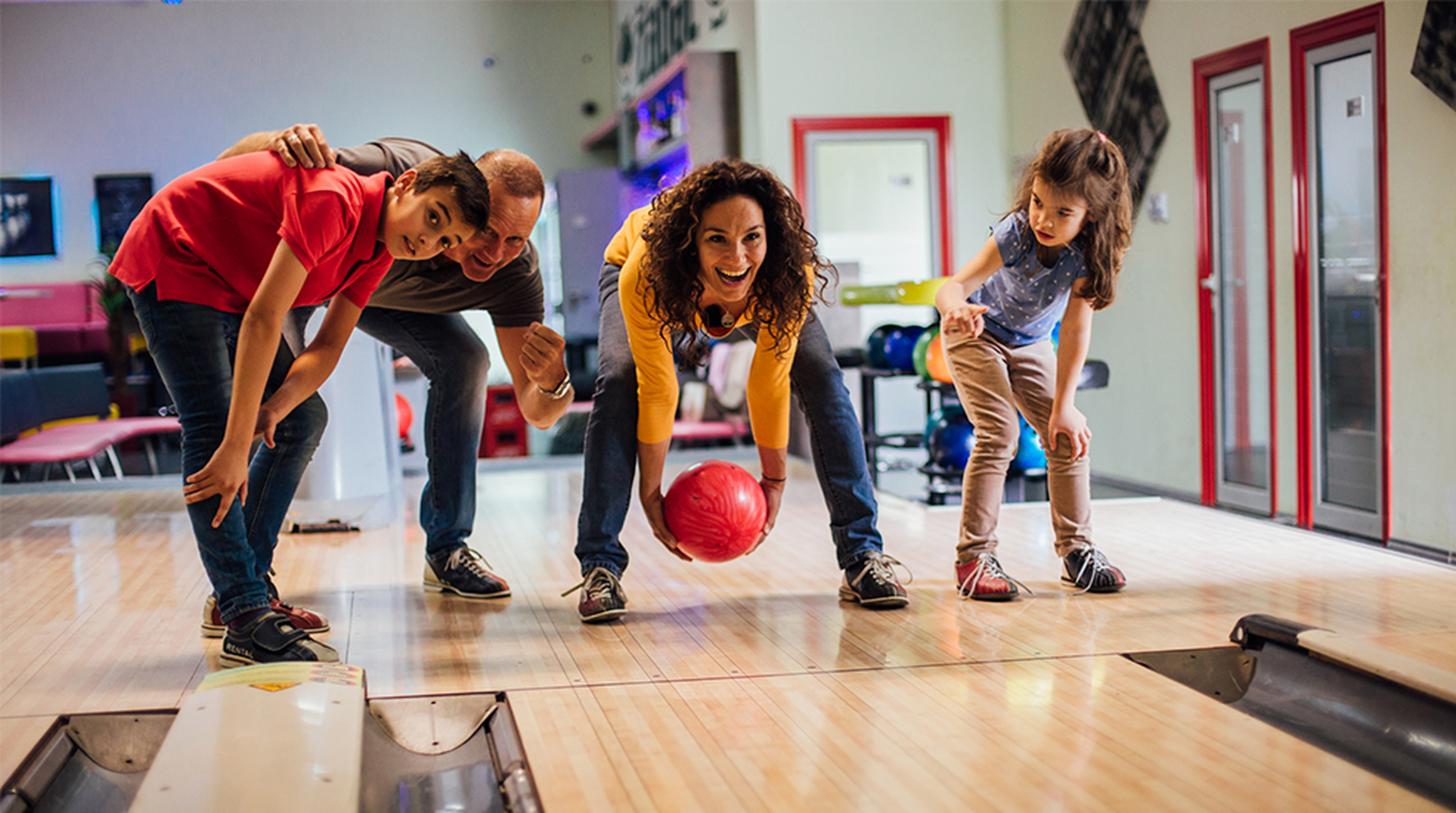 Smiling young family bowling together