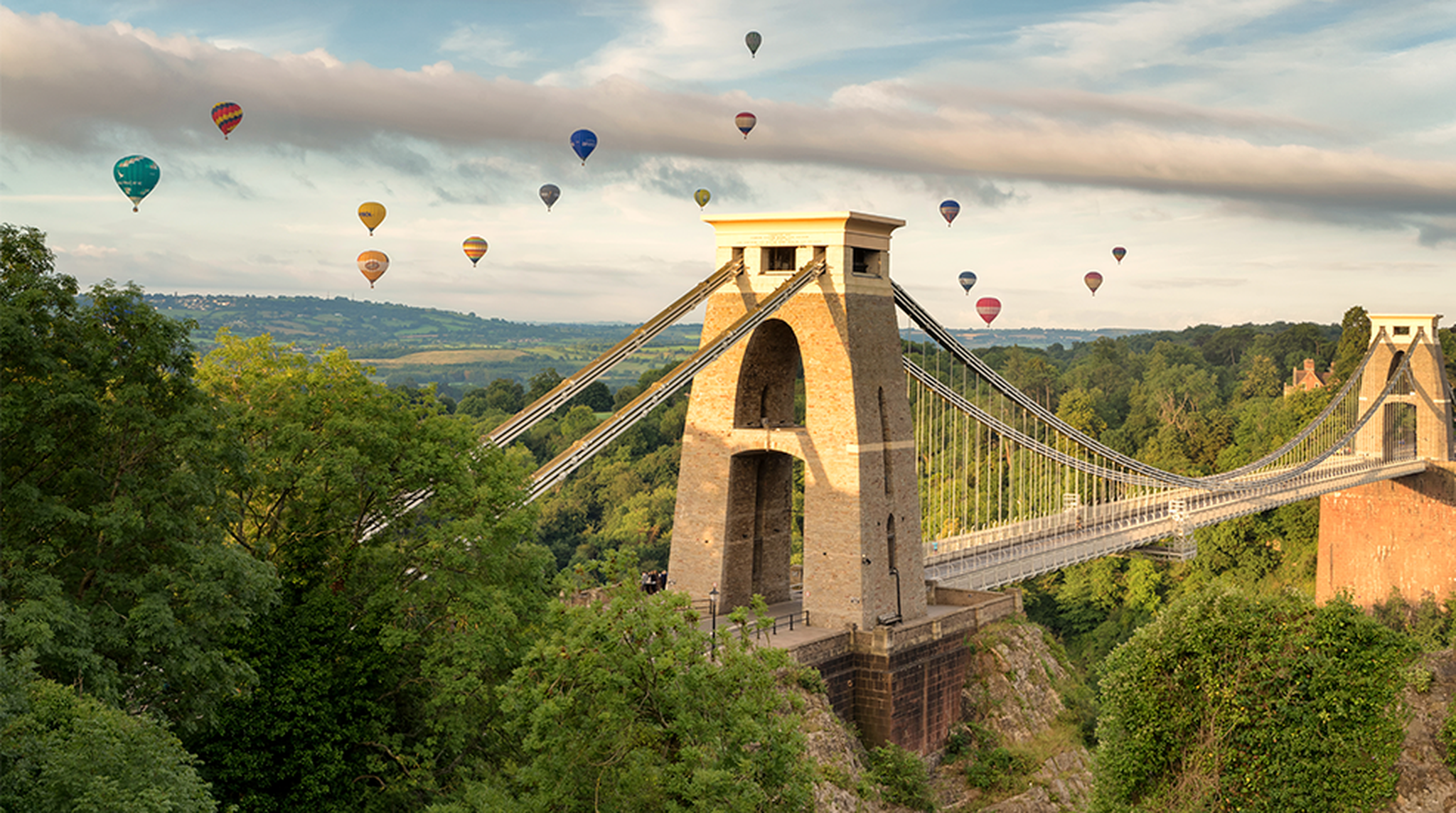 Hot air balloons flying above the Clifton Suspension Bridge as a part of Bristol Balloon Fiesta