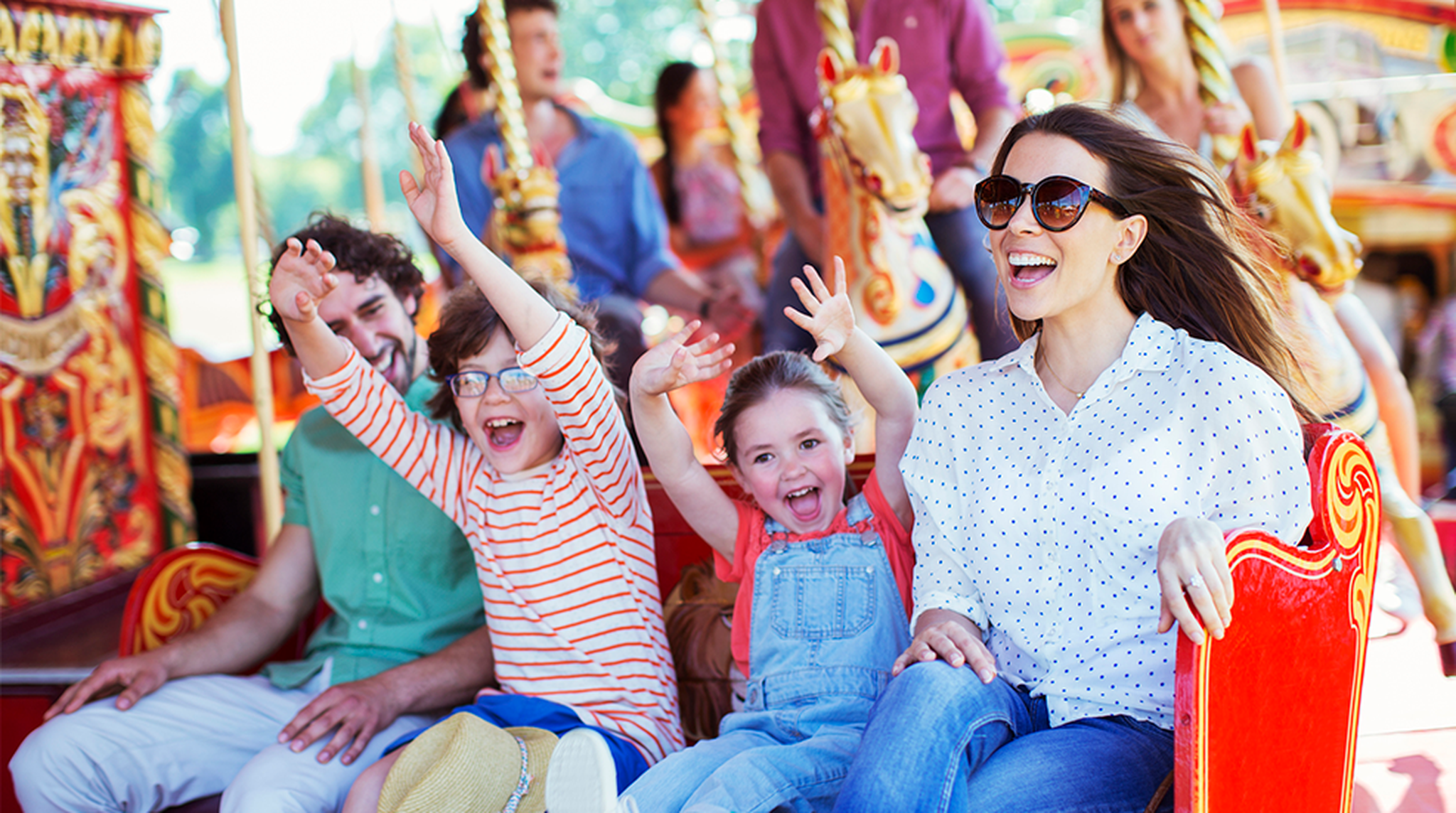 Family on carousel in amusement park