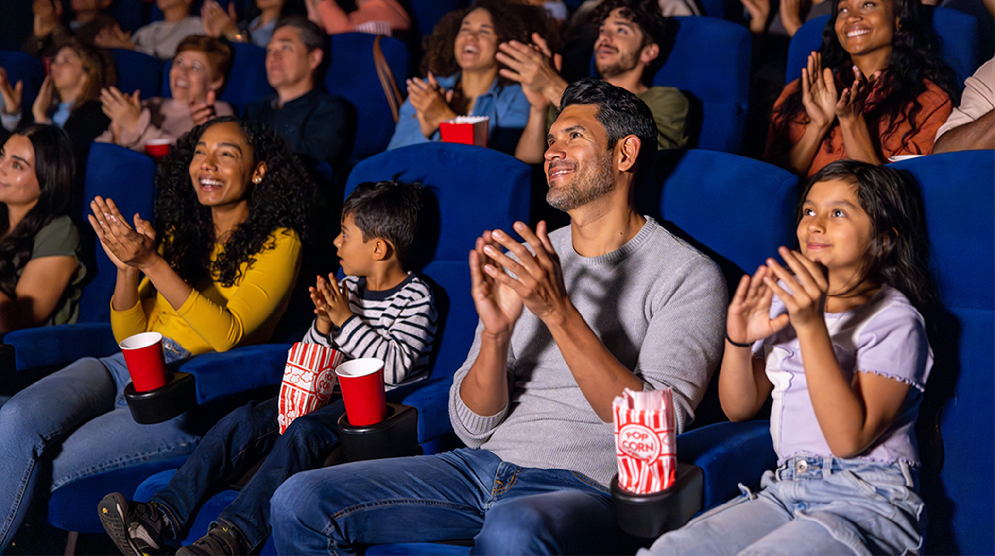 Happy family applauding in the cinema after watching a movie