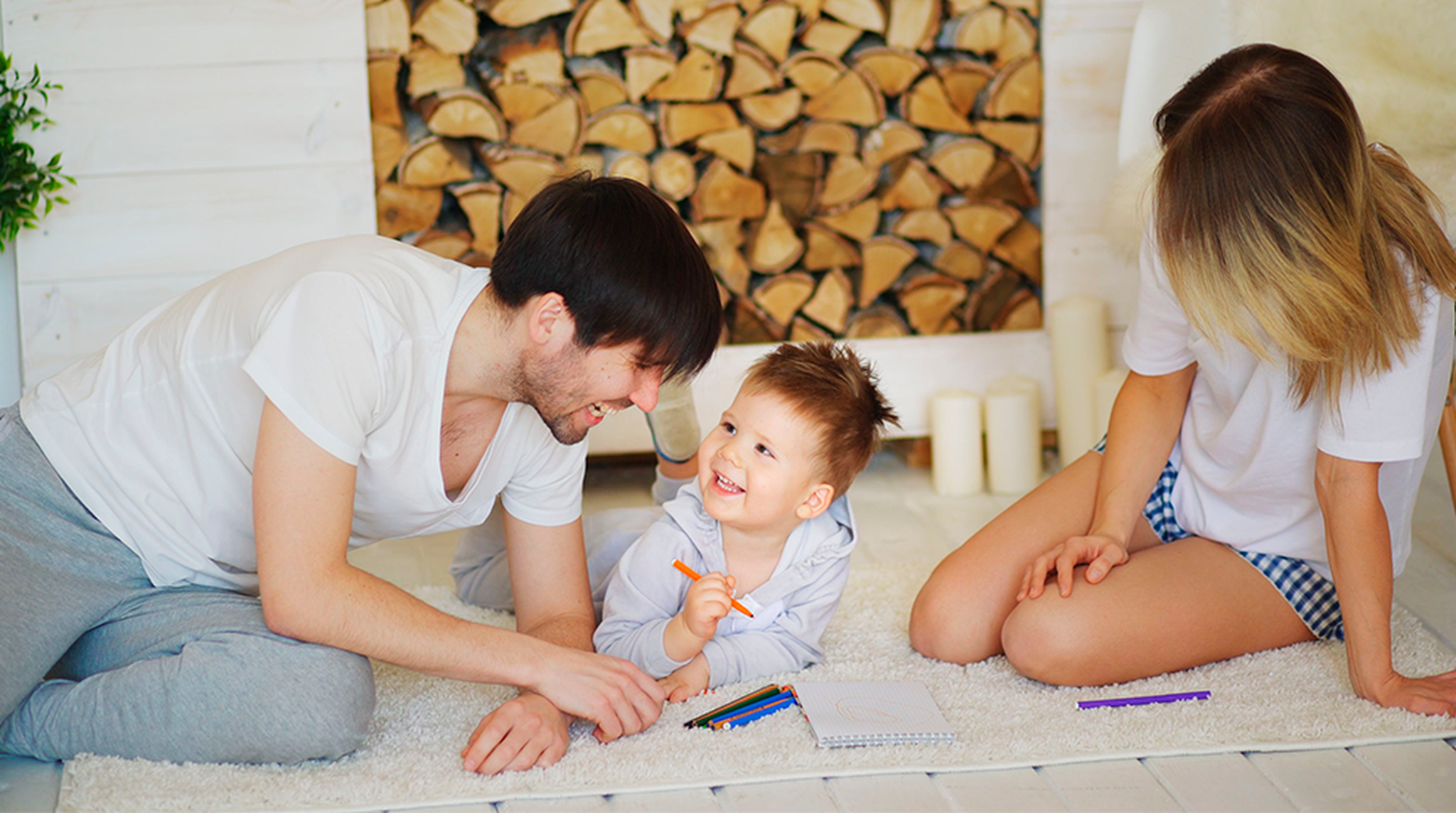 Happy family drawing together on living room floor, fostering creativity and bonding time