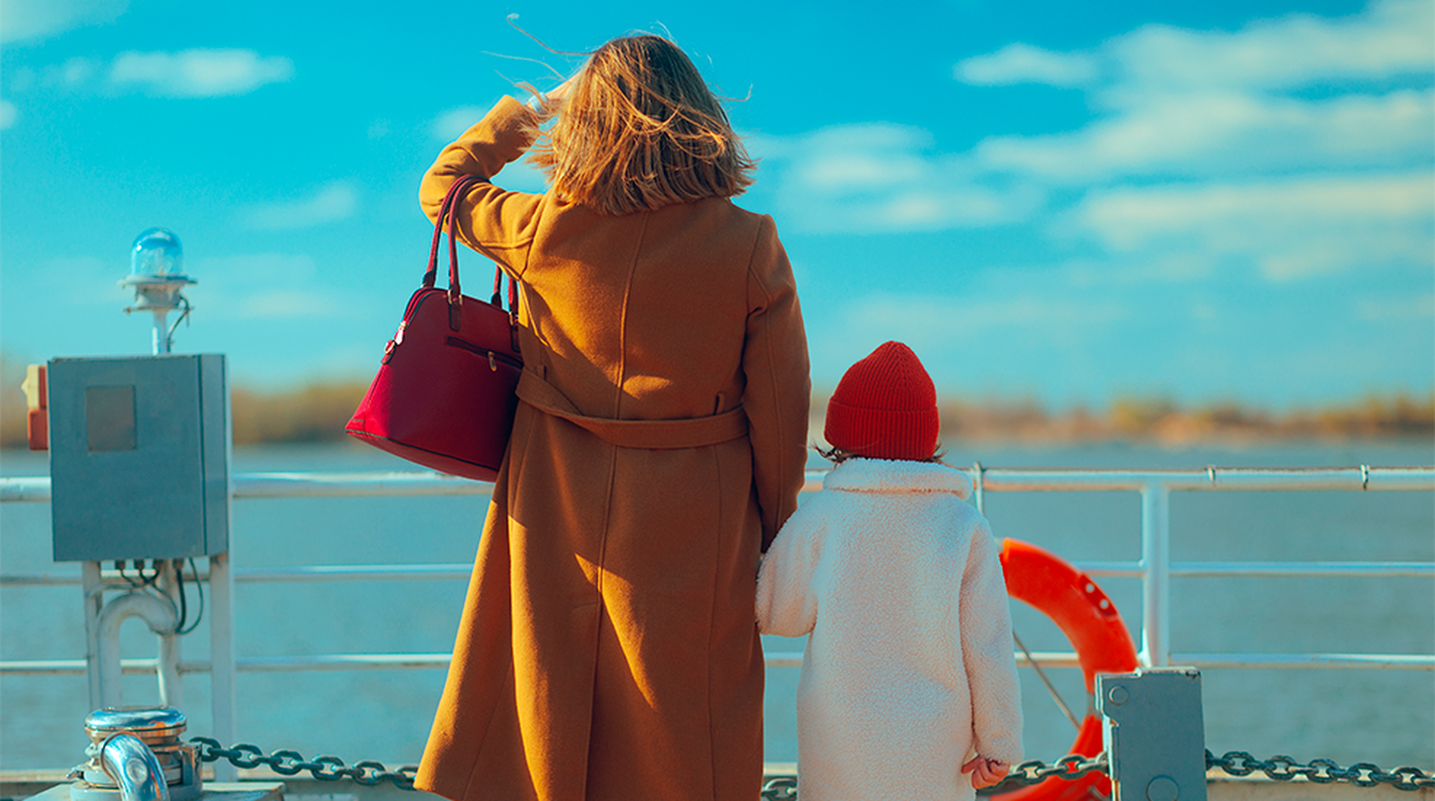 A woman and a child on a boat, looking at the water