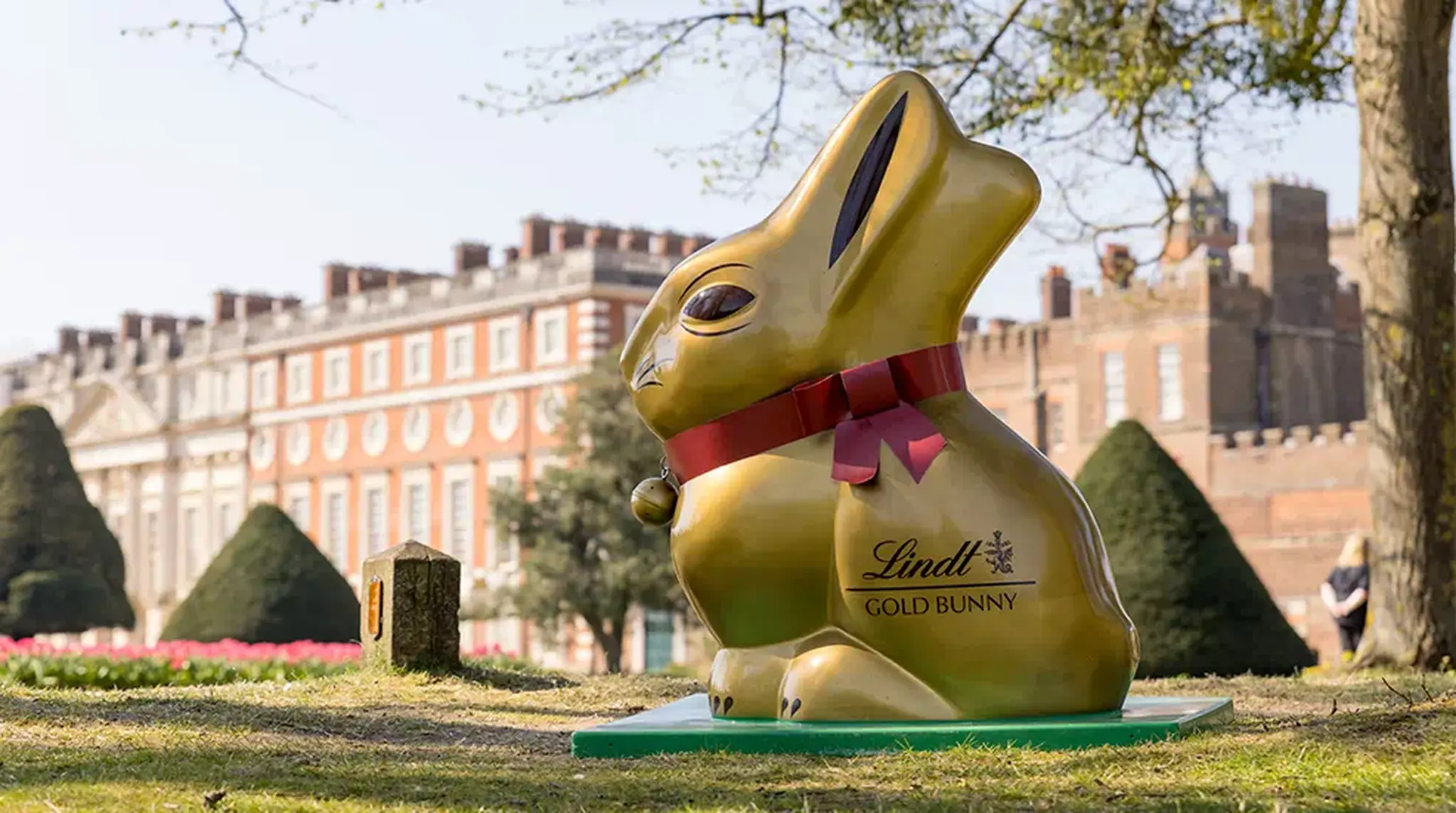 A large Lindt Gold Bunny sculpture sitting in front of a historic building