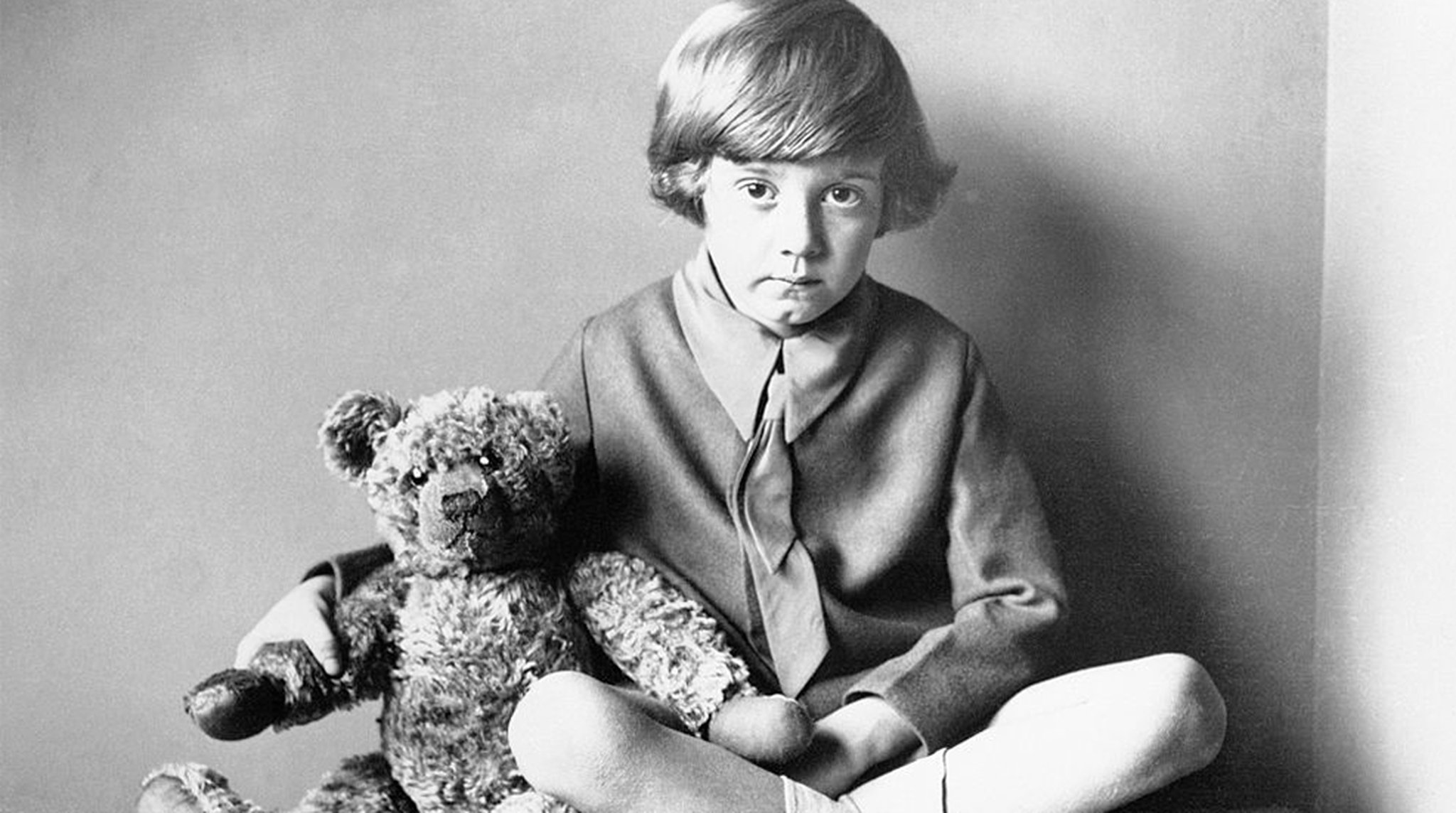 Winnie the Pooh author A.A. Milne's son, Christopher Robin, sitting at home with his teddy bear, circa 1925