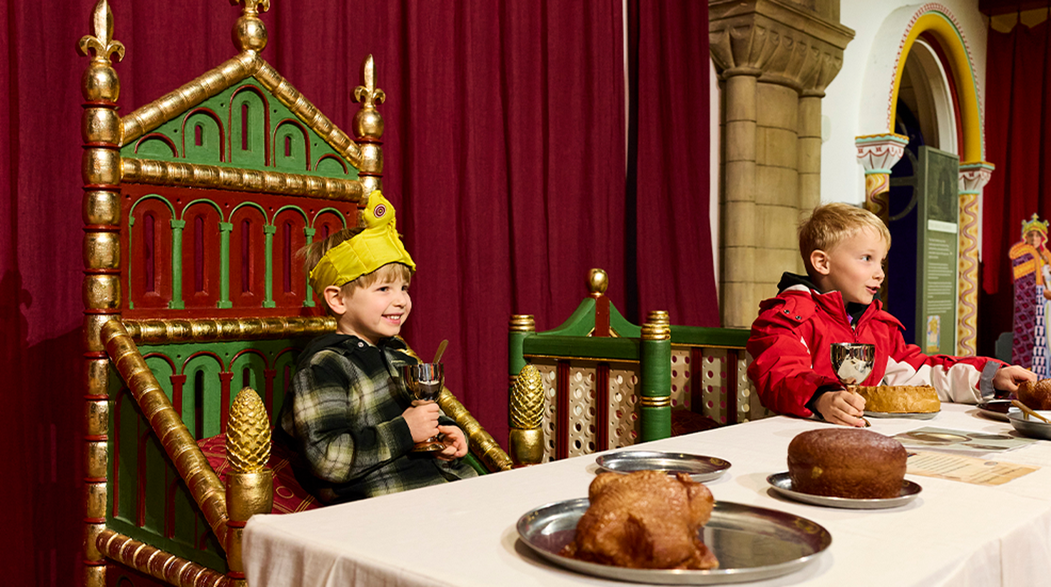 Children pose in thrones at Norwich Castle Museum & Art Gallery