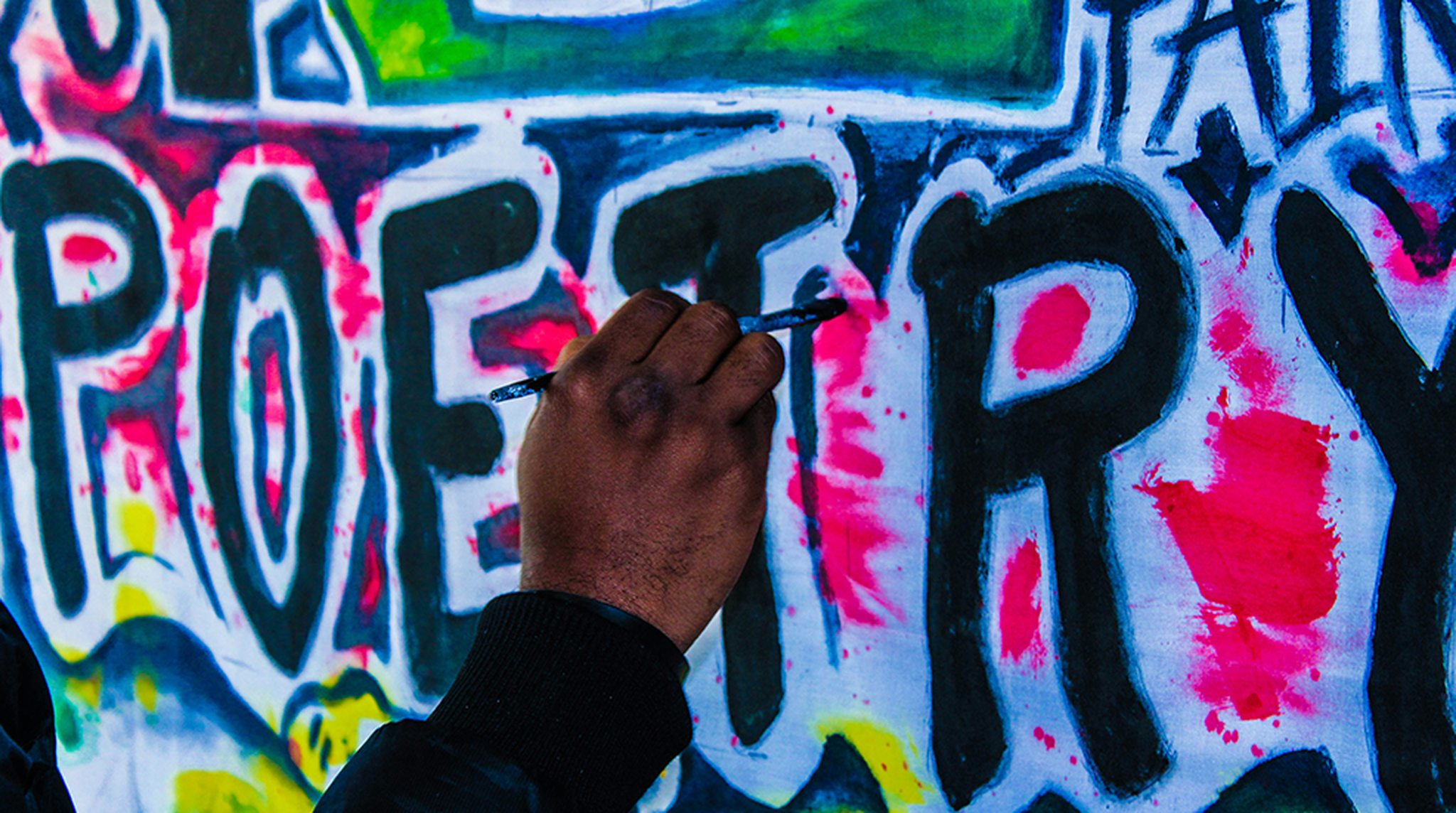 The word 'poetry' graffitied on a wall