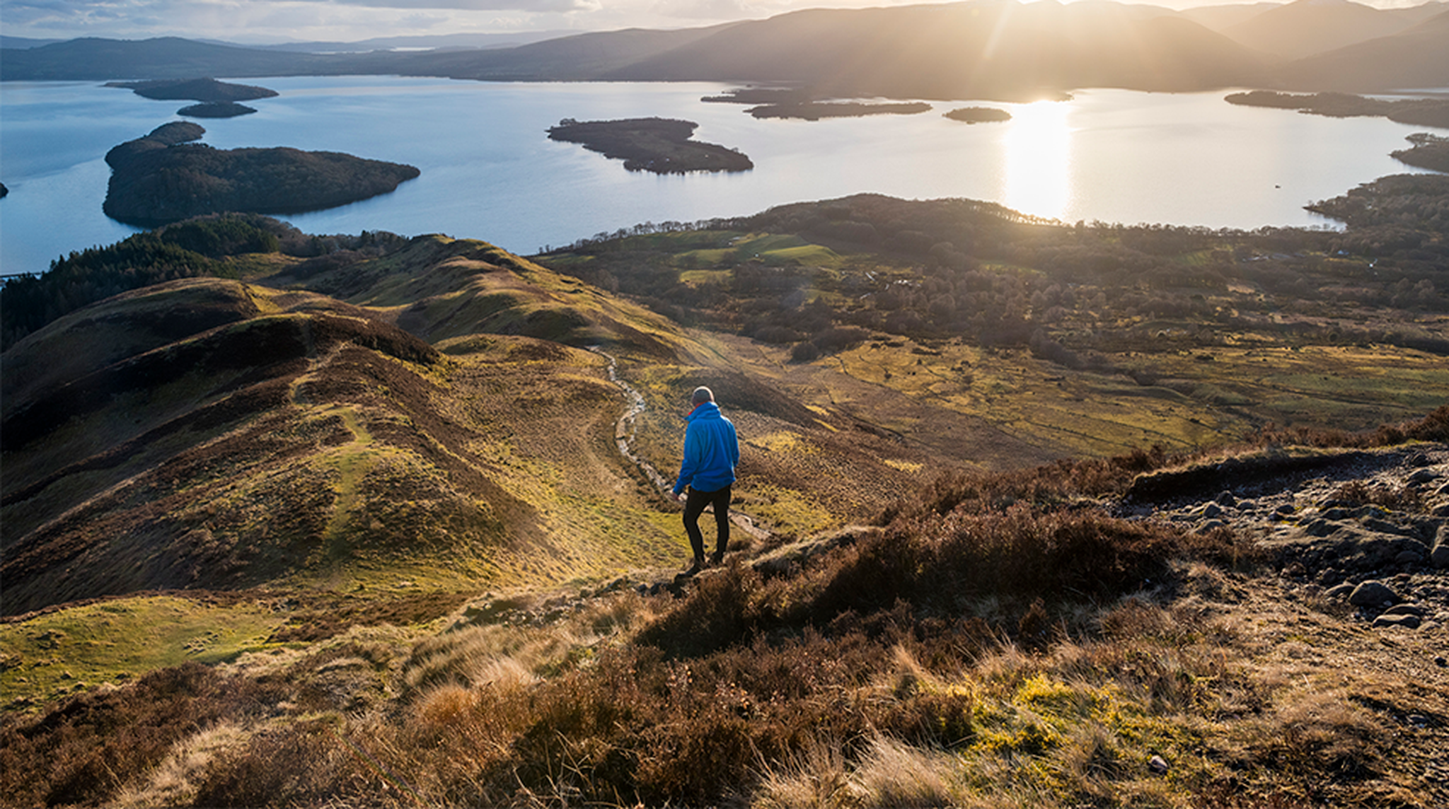 Hiking down from the top of Conic Hill towards Loch Lomond along The West Highland Way