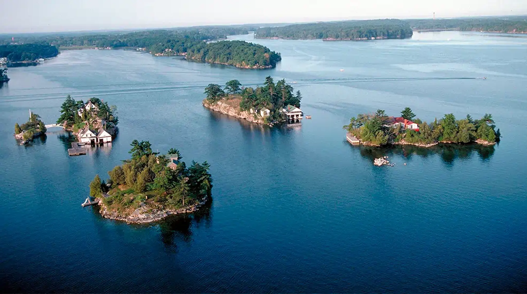 Aerial view of water with several small, tree-covered islands scattered across