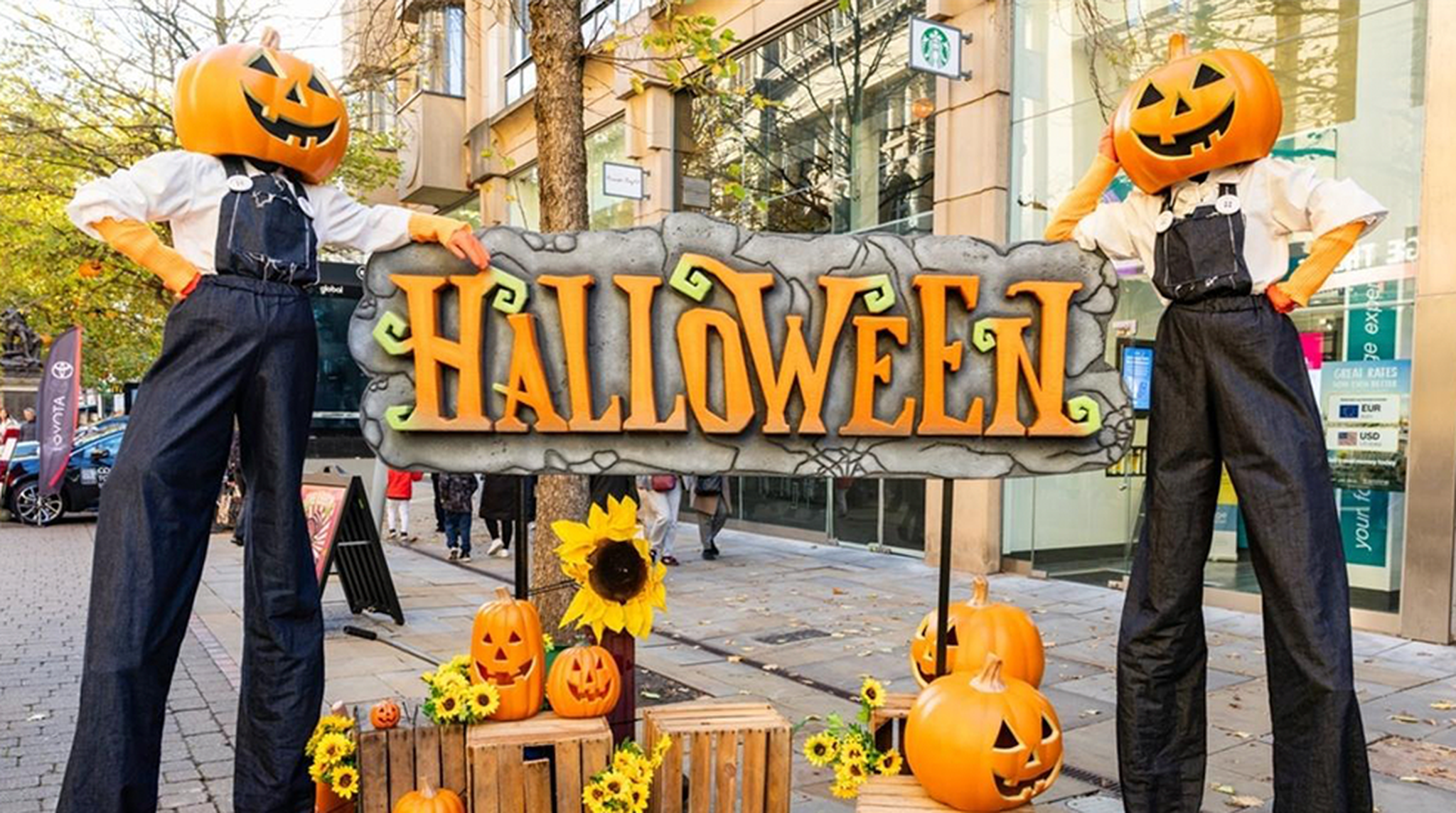 Halloween sign and two pumpkin head scarecrows